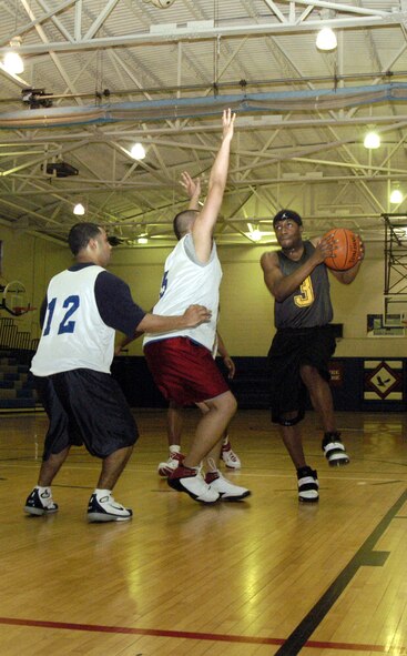 Airman Quinn Stephens, 436th Aerial Port Squadron, attempts to make a layup as the 436th Mission Support Squadron players try to block him. The 436th MSS won against 436th APS (B) 52-35. (U.S. Air Force photo/Airman 1st Class Shen-Chia Chu)