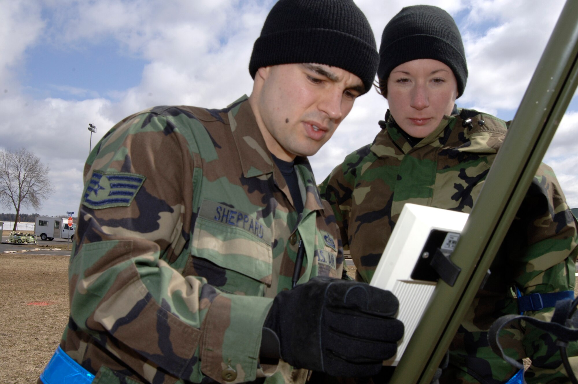 VOLK FIELD AIR NATIONAL GUARD BASE, Wis. -- Staff Sgt. Wesley Sheppard and Senior Airman Lisa Cochran, weather specialist, set up a terminal for a weather reading machine on April 1 at an exercise in Volk Field.  Weather information is vital for the base commander to make accurate decisions on flying, maintenance and the over all safety of service members. (Photo by Tech. Sgt. Chyrece Campbell)