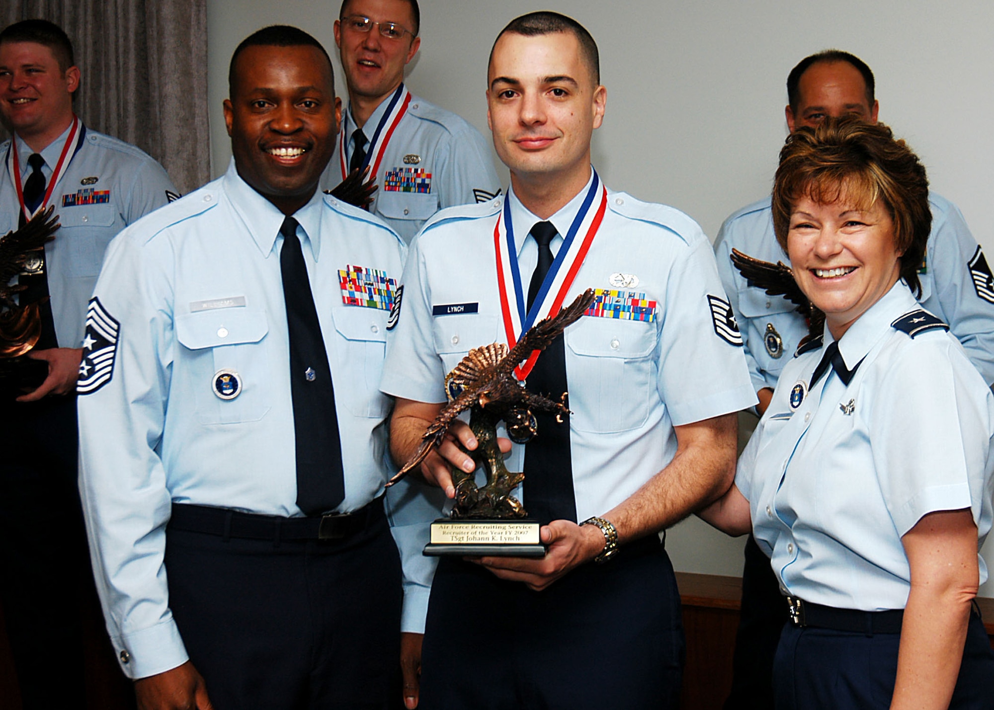 Air Force Recruiting Service Commander Brig. Gen. Suzanne Vautrinot, right, and Command Chief Master Sgt. Reginald Williams congratulate Tech. Sgt Johann Lynch, 341st Recruiting Squadron, in a ceremony on Randolph Air Force Base, Texas, April 2 for winning the unit’s Recruiter of the Year award. The sergeant assigned to San Antonio, Texas, is one of the Air Education and Training Command 12 Outstanding Airmen of the Year and moves on to compete at Air Force-level. (U.S. Air Force photo/Staff Sgt. Jennifer Lindsey)