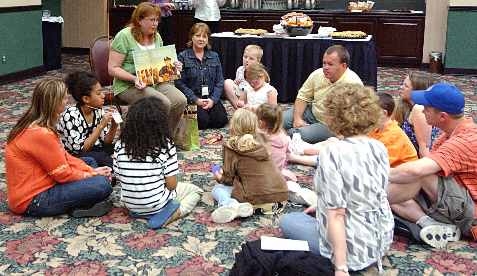 Children – and a few parents -- listen to an adult volunteer read “Mercedes and the Chocolate Pilot” during the Tell Me a Story™ event sponsored by the Texas Military Forces State Family Program in Austin March 29. (Texas Military Forces photo by Sgt. Ann Benson)