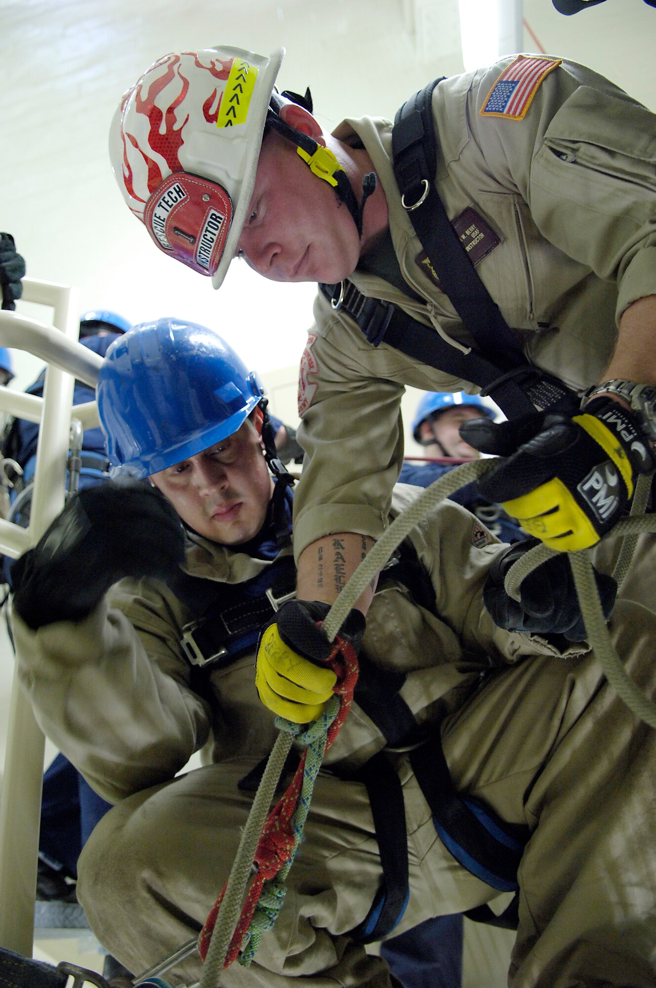 Right, Tech. Sgt. Jason Berry, Department of Defense Fire Academy instructor, Goodfellow AFB, TX, shows Airman 1st Class Jesse Crespo, a 305th Civil Engineer firefighter, how to setup a belay device for rappelling down a staircase. Sergeant Berry came to McGuire to teach the Rescue Technician 1 course to firemen from McGuire and Fort Dix. The course entailed Auto-Extraction Skills, High Angle Rope Rescue Skill and Confined Space Rescue Skill. (U.S. Air Force photo/Kenn Mann)