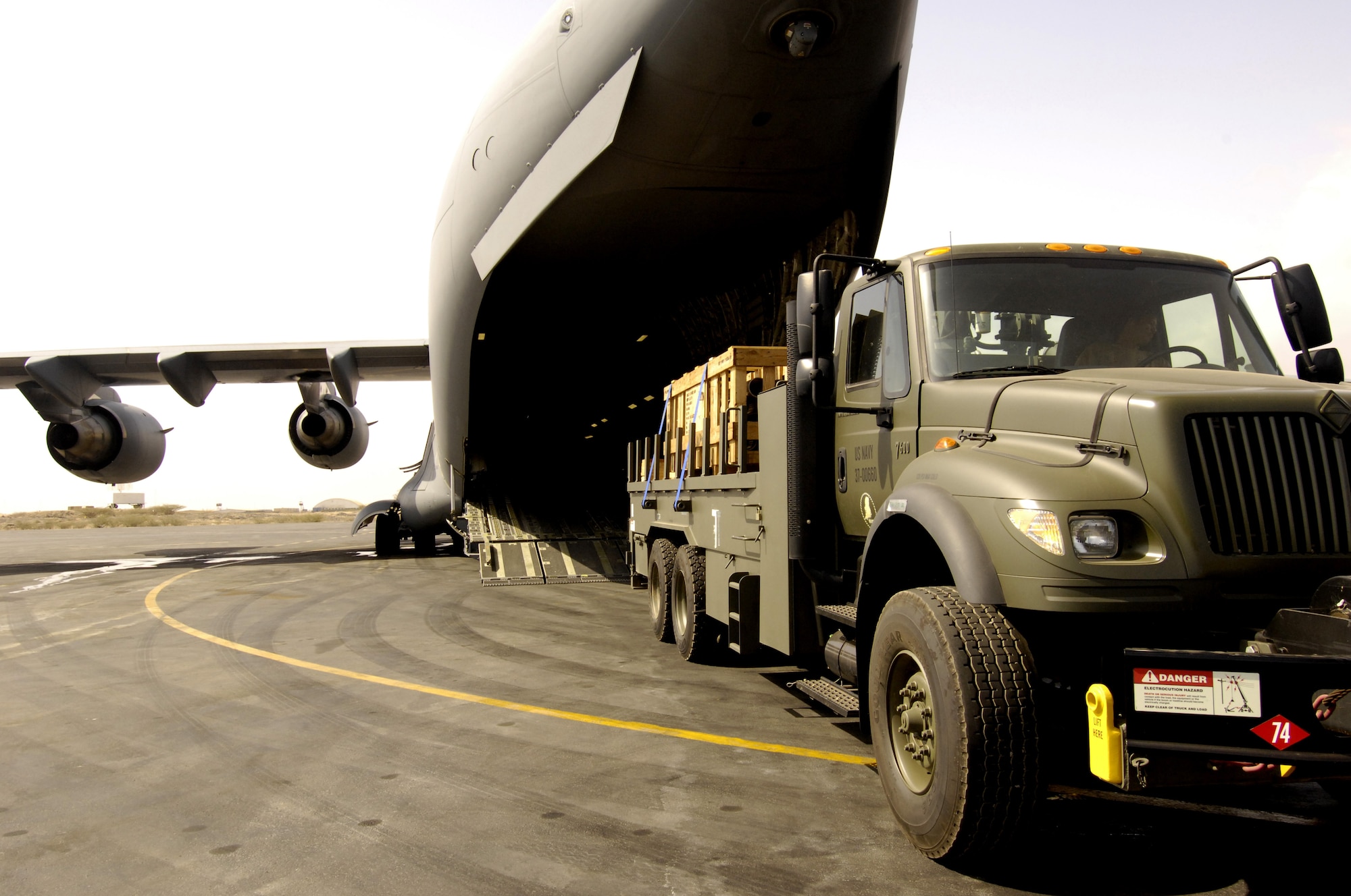 U.S. Navy Seabees load a support truck and supplies in to a C-17 Globemaster III to be transported, along with 20 Navy Seabees, to Nairobi, Kenya from Camp Lemonier, Djibouti. The Seabees are forward deploying to Kenya in support of a humanitarian well drilling mission enabling critical water supplies to regions in severe drought conditions.    (U.S. Air Force Photo By: Staff Sgt. Christina M. Styer) 