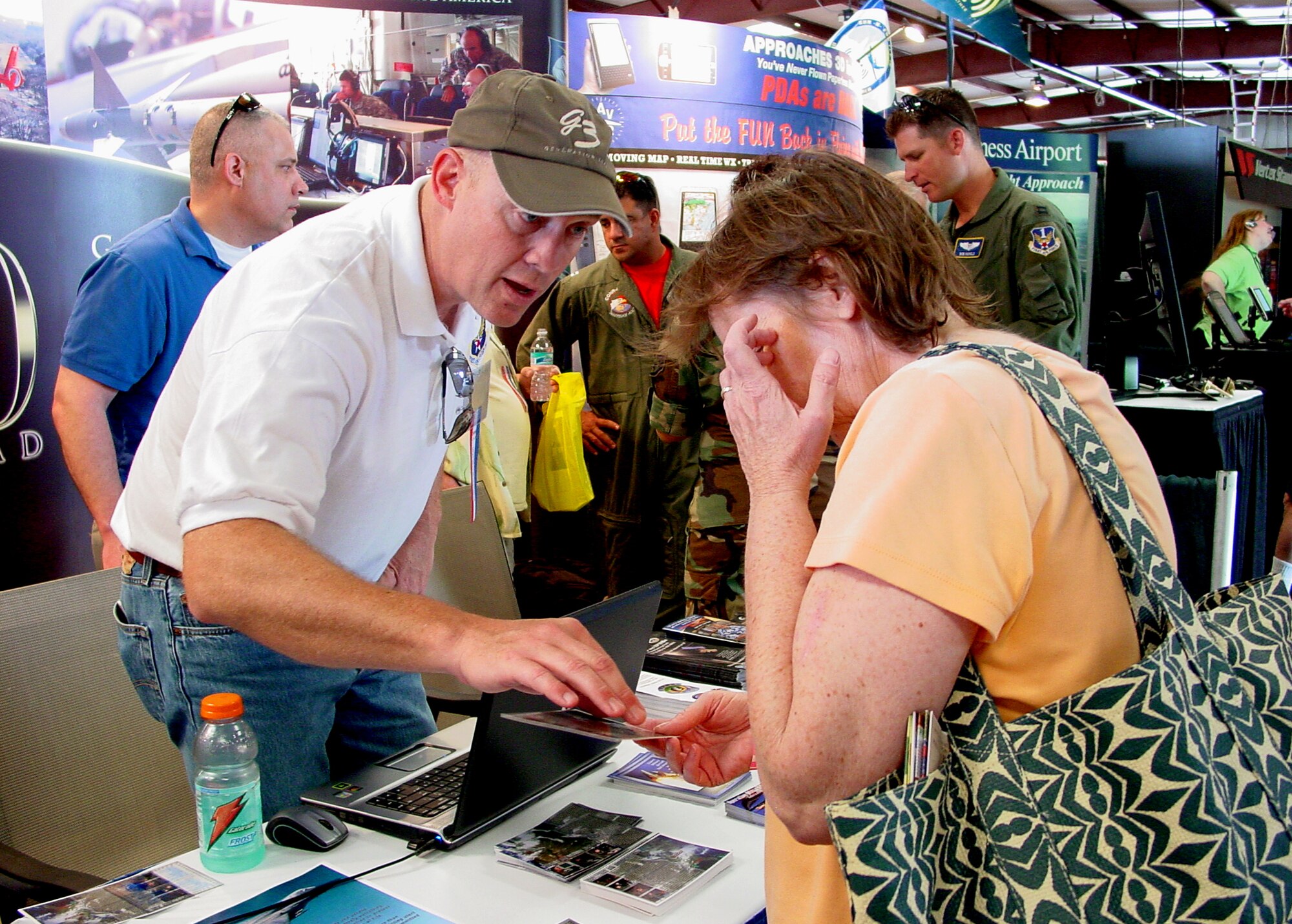 Mike Strickler of the Continental U.S. NORAD Region discusses a NORAD mission with a Sun ?n Fun attendee here.  A joint-service CONR team is at the EAA-sponsored event to discuss topics of interest with general aviators, including NORAD?s 50th anniversary celebration.  (U.S. Air Force photo)                          