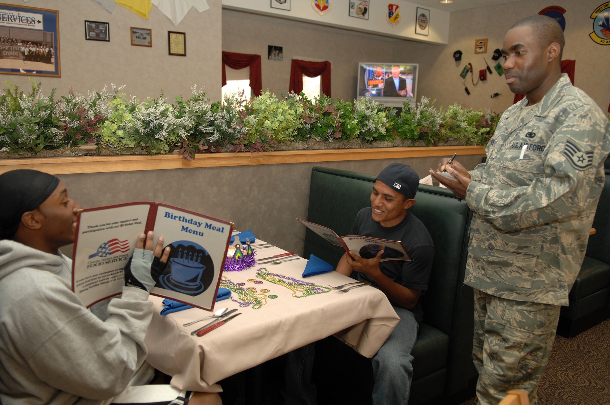 HOLLOMAN AIR FORCE BASE, N.M. -- Staff Sgt. Carlton Francis, 49th Materiel Maintenance Support Squadron, takes the orders of Airman 1st Class Devante Bates and Airman 1st Class Luis Ogaz, both from 49th MMSS here March 18. Sergeant Francis, a member of the Middle Two, is serving the Airmen who recently had a birthday as part of the birthday party the Shifting Sands Dining Facility holds quarterly. (U.S. Air Force photo by Airman Sondra M. Wieseler)