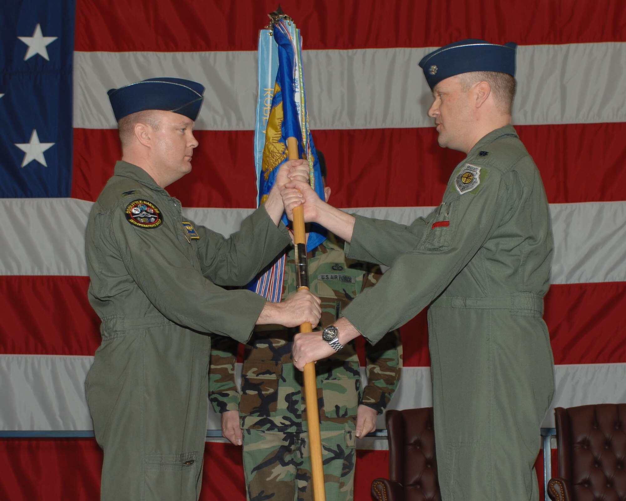 (Right to left) Lt. Col. James Pryor, outgoing 34th Bomb Squadron commander, hands the guidon to Col. "Buck" Shawhan, 28th Operations Group commander, during a change of command ceremony April 4. By handing the guidon off, Colonel Pryor relinquishes command of the 34th Bomb Squadron. (U.S. Air Force photo/Airman 1st Class Joshua Seybert)
