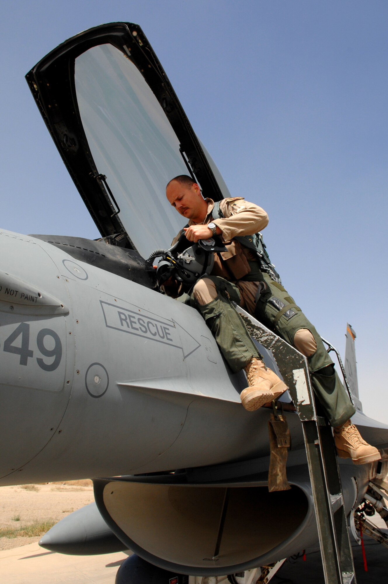 BALAD AIR BASE, Iraq - Maj. Dag Grantham, 332nd Expeditionary Fighter Squadron F-16 pilot, prepares his equipment for a mission here, April 9. The F-16 Fighting Falcon is a compact, multi-role fighter aircraft, which is highly maneuverable and has proven itself in air-to-air combat and air-to-surface attack. Major Grantham is deployed from Luke Air Force Base, Ariz. (U.S. Air Force photo /Senior Airman Julianne Showalter)