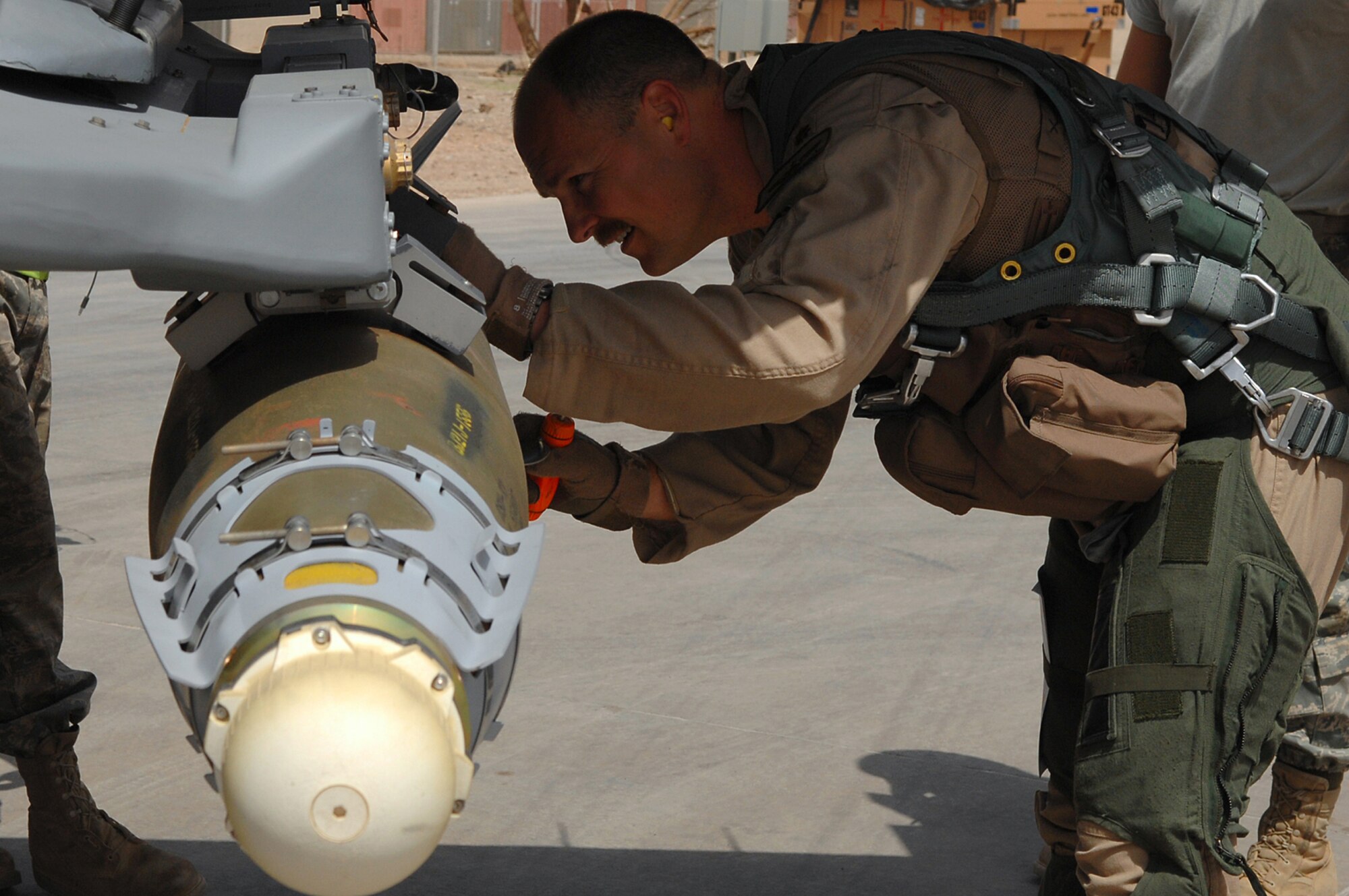 BALAD AIR BASE, Iraq - Maj. Dag Grantham, 332nd Expeditionary Fighter Squadron F-16 pilot, inspects munitions during a pre-flight check here, April 9. Before a mission pilots must inspect the munitions loaded on the aircraft to ensure they are installed and connected correctly. The F-16 Fighting Falcon is a compact, multi-role fighter aircraft, which is highly maneuverable and has proven itself in air-to-air combat and air-to-surface attack. Major Grantham is deployed from Luke Air Force Base, Ariz. (U.S. Air Force photo /Senior Airman Julianne Showalter)