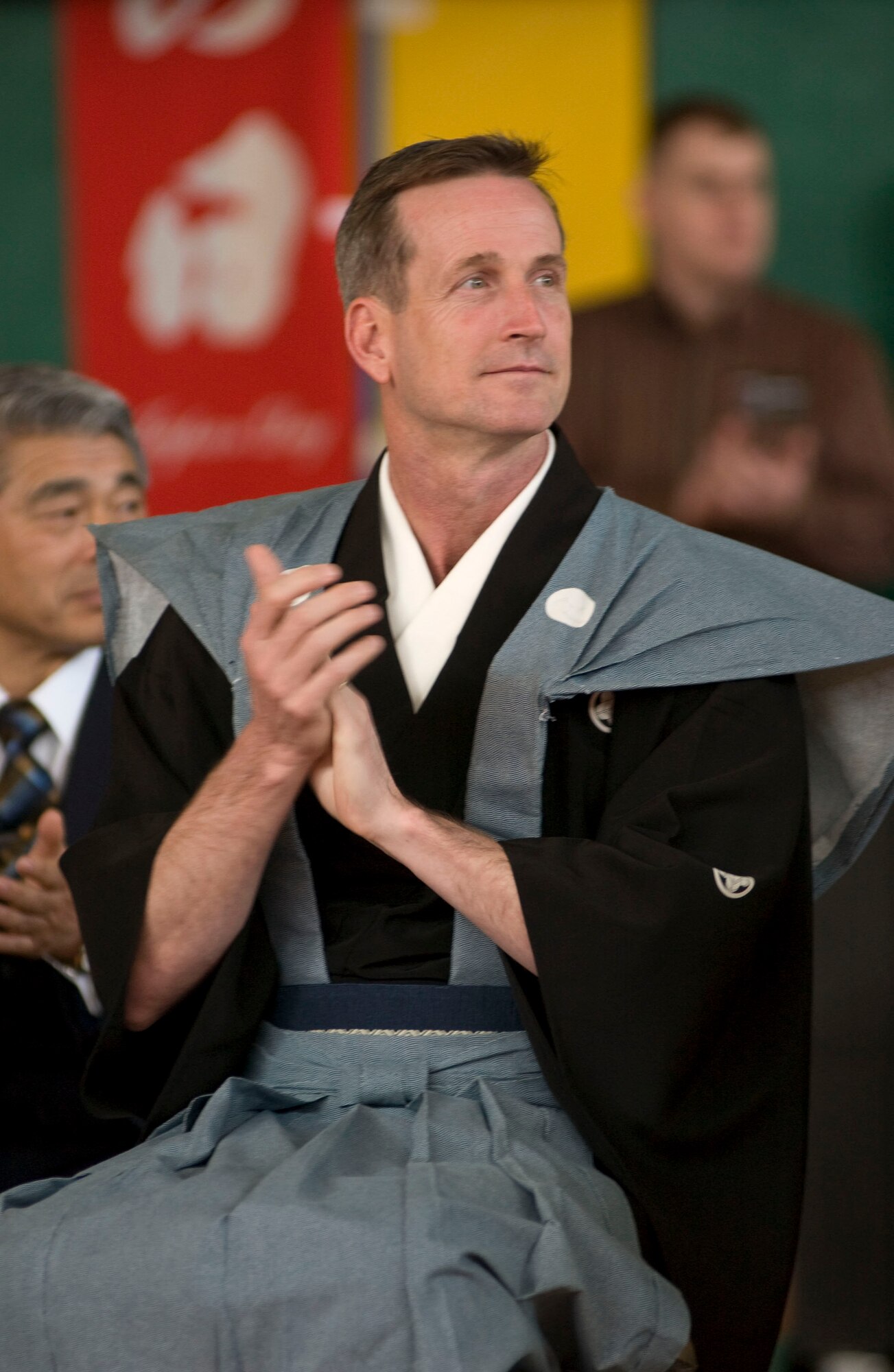 MISAWA AIR BASE, Japan -- Colonel Terrance O'Shaughnessy, commander of the 35 Fighter Wing applauds a speaker during the opening ceremony of "Japan Day" at Edgren High School on April 5, 2008. Col. O'Shaughnessy wore a Japanese kimono to add to the spirit of cultural exchange that permeated the event. (U.S. Air Force photo by Senior Airman Samuel Morse)