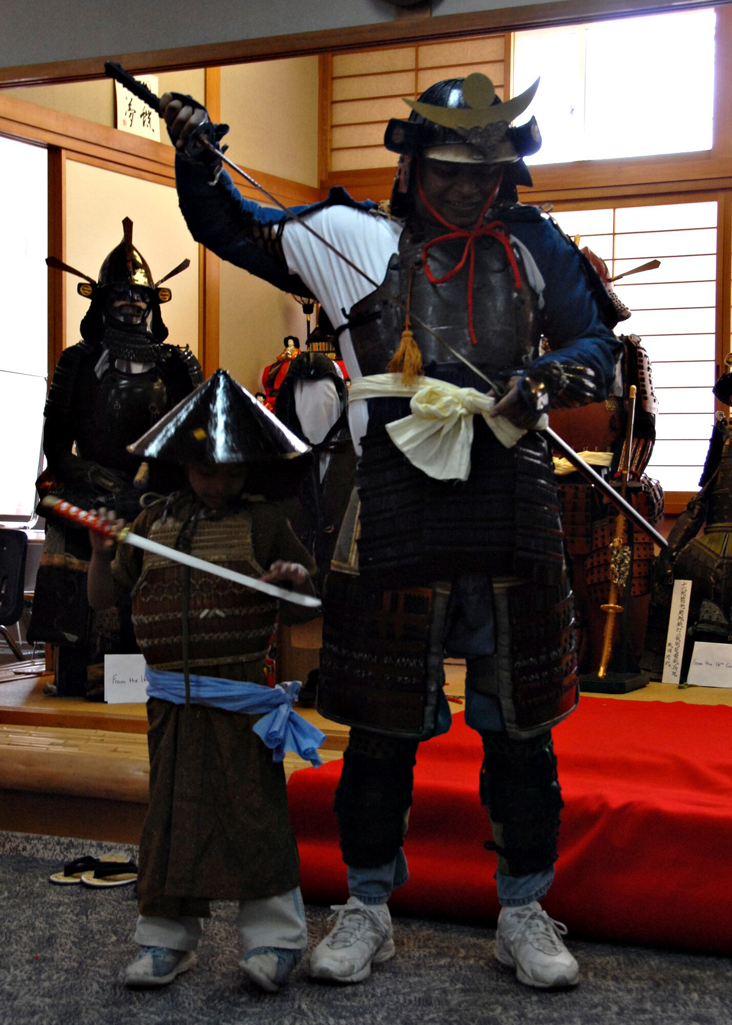 MISAWA AIR BASE, Japan – Robert Knowles tries on Sakurada armor with his daughter Victoria Knowles, age 6, during Japan Day here April 5, 2008. Japanese armor was worn by the shogun, highest military class, samurai and emperors. (U.S. Air Force photo by Staff Sgt. Rachel Martinez)