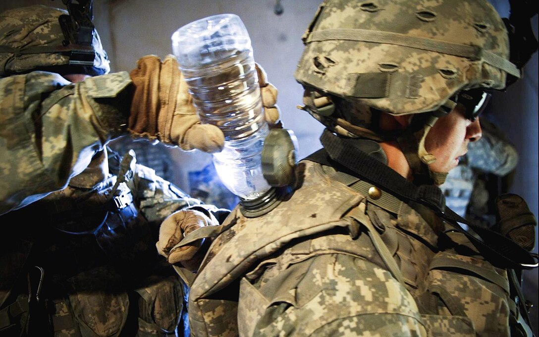 U.S. soldiers refill each others’ Camelbak canteens as they prepare to conduct a three-day air assault mission in the village of Upper Dugmut to search for high-value insurgents and weapon caches during Operation Courage Thunder 3, in Kirkuk province, Iraq, April 3, 2008.  The soldiers are assigned to the 10th Mountain Division's Company C, 2nd Battalion, 22nd Infantry Regiment.  
