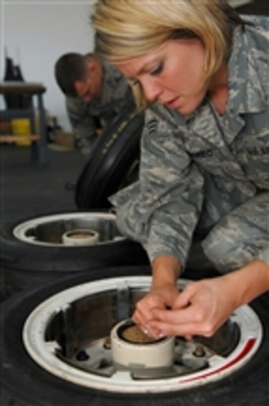Senior Airman Melissa Gallardore places retaining rings on a wheel from the main landing gear of F-16 Fighting Falcon aircraft at Balad Air Base, Iraq, on March 29, 2008.  Gallardore is a crew chief with the 332nd Expeditionary Maintenance Squadron deployed from the Montana Air National Guard.  