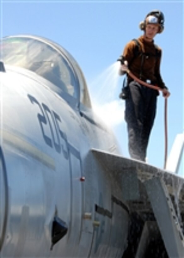 Navy Airman Josh Bekkbring washes down an F/A-18E Super Hornet aircraft parked on the flight deck of the aircraft carrier USS Abraham Lincoln (CVN 72) as the ship operates in the Pacific Ocean on April 10, 2008.  The Super Hornet is attached to Strike Fight Squadron 137.  