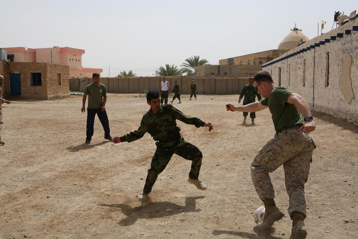 Cpl. Josh A. Covert, 26, a squad leader from Farmington, N.M., assigned to I Company, 3rd Battalion, 4th Marine Regiment, Regimental Combat Team 5, makes a move to get by an Iraqi Security Force guard during a soccer game at Hit, Iraq, April 10. Marines played the PSF in an intense game of soccer with the Marines pulling out the victory 10-8. It was the fourth time the units played each other, but the first time the Marines have won.