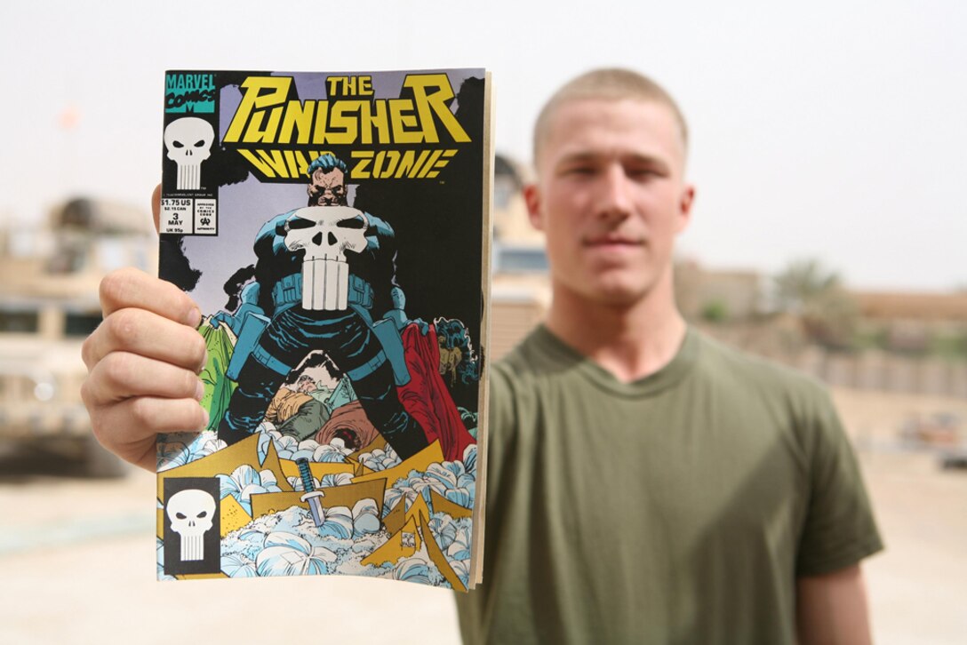 Lance Cpl. Brandon M. Barnes, 21, a team leader from Fairbanks, Ala., assigned to I Company, 3rd Battalion, 4th Marine Regiment, Regimental Combat Team 5, holds out one of the comic books that Marines pass out to Iraqi children at Camp Hit, Iraq, April 10. Barnes' uncle and mom sent him packages with comic books in them. Barnes' decided to hand out the comics he doesn't read to the kids in the city. Before Marines give them away, he scans the comics for any pictures that may be offensive to the Iraqi people.