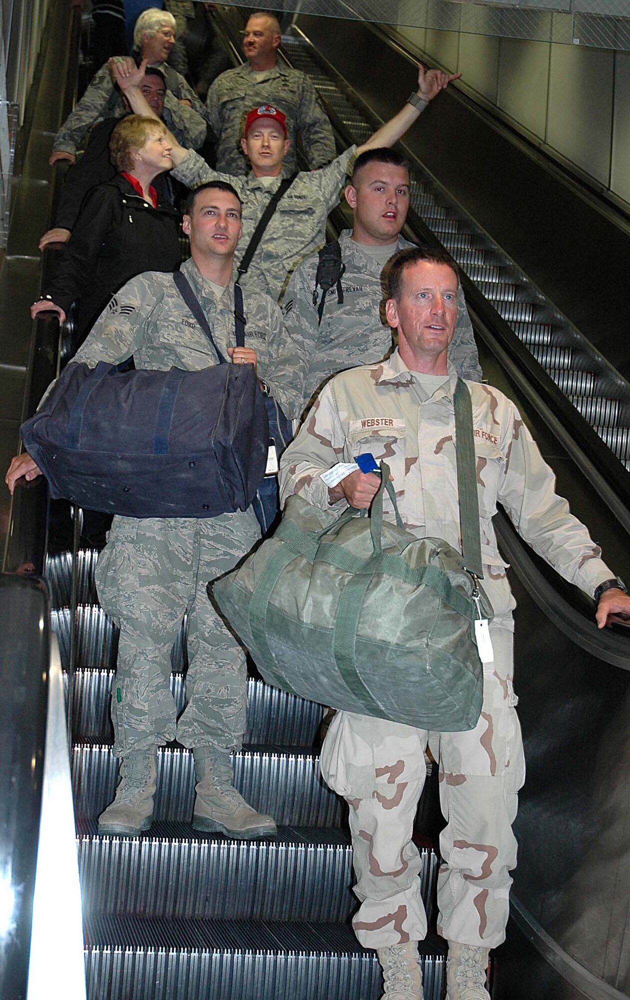 Reservists from the 446th Civil Engineer Squadron at McChord Air Force Base, Wash., descend an escalator at SeaTac International Airport April 10 after receiving a hearty welcome home from Iraq. The Airmen, who were deployed for six months, assisted with construction of buildings for the Army, Marines and Air Force forces in Iraq.  While deployed the Airmen labored under extreme weather conditions ranging from 90 degree heatwaves to frosty 20 degree weather and snow. (U.S. Air Force photo/Airman First Class Patrick Cabellon)