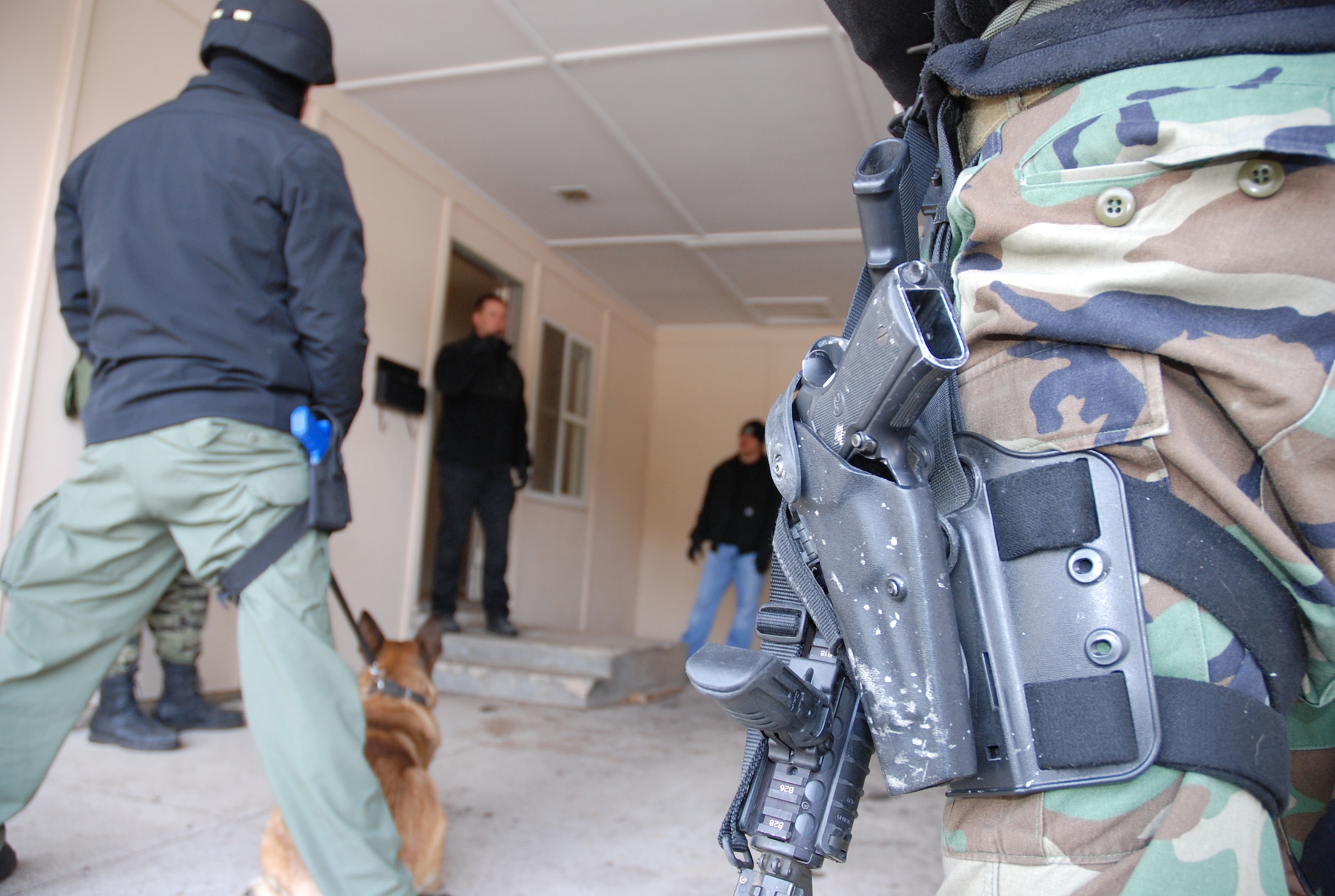 Sean Hartley, a canine unit trainer with the El Paso County Sheriff’s Office, covers several tactics in between scenario training with military and civilian law enforcement officials April 11 in the U.S. Air Force Academy base housing complex. Sergeant Hartley, together with several other agencies around the Colorado Springs area, participated in canine Special Weapons and Tactics, or ‘SWAT’ training to better understand the use of civilian and military working dogs during a tactical engagement with criminal or unfriendly forces. (U.S. Air Force photo/Senior Airman Stephen Collier)