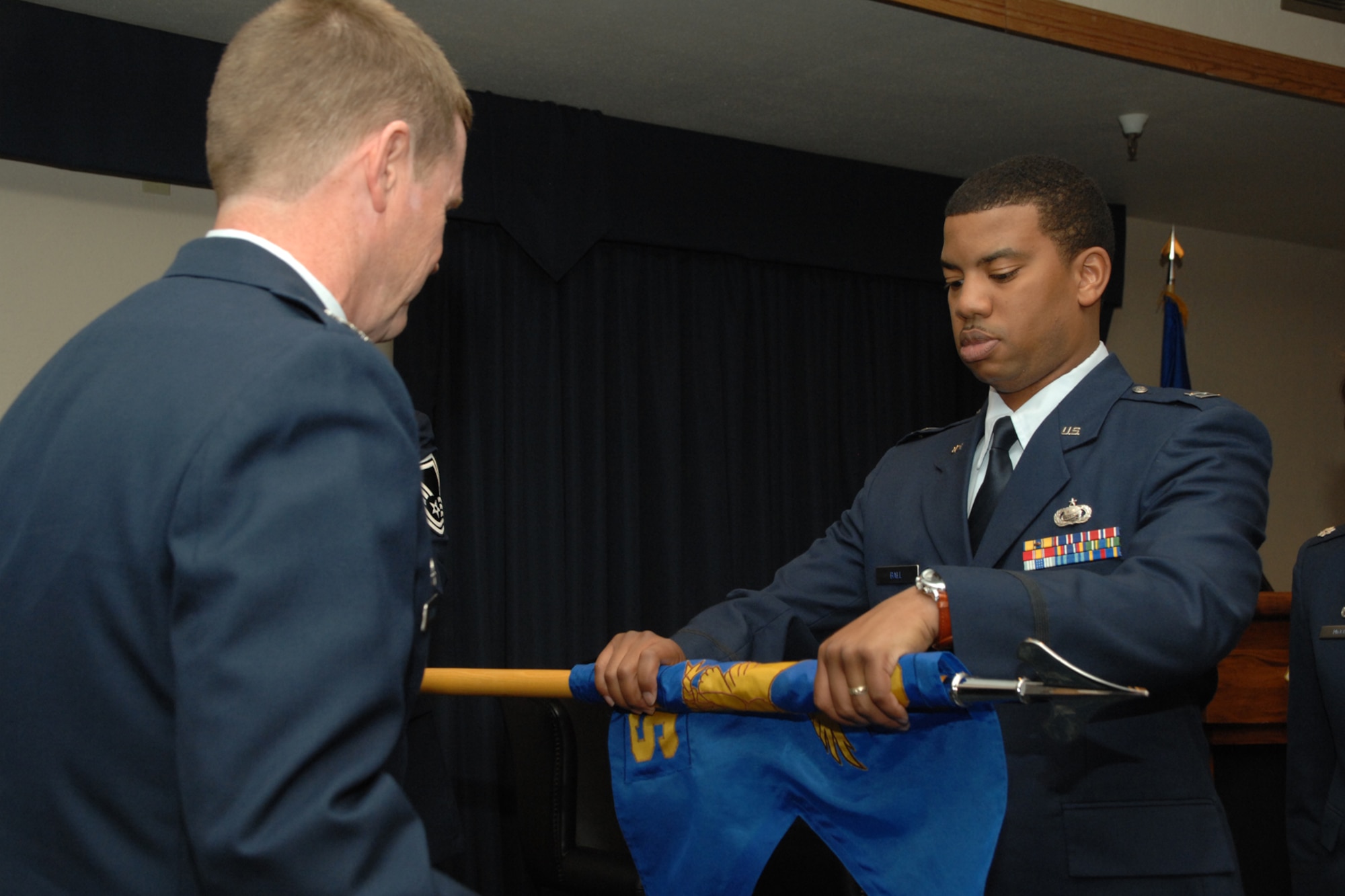 HOLLOMAN AIR FORCE BASE, N.M. --  Capt. J. Isaiah Ball, former 49th Mission Support Squadron commander, cases the squadron guidon during a squadron merger ceremony here April 4. Assisting him is 49th Mission Support Group Commander Col. Mark Engeman.