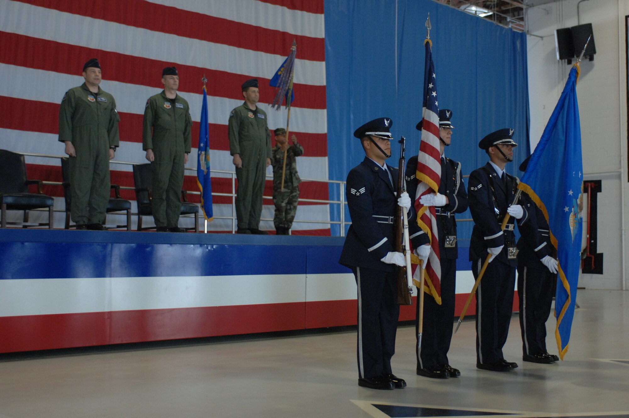 SHAW AIR FORCE BASE, S.C.--Col. John Colombo, 20th FW Operations Group commander (left), Lt. Col. Tom Littleton, outgoing 20th FW Operations Support Squadron commander and Lt. Col. William Culver (right), new 20th FW OSS/CC stand at attention as 20th FW Honor Guard members present the colors for the OSS change of command here April 11 at 10 a.m. inside Hangar 1200. (U.S. Air Force photo/Airman 1st Class Matthew Davis)