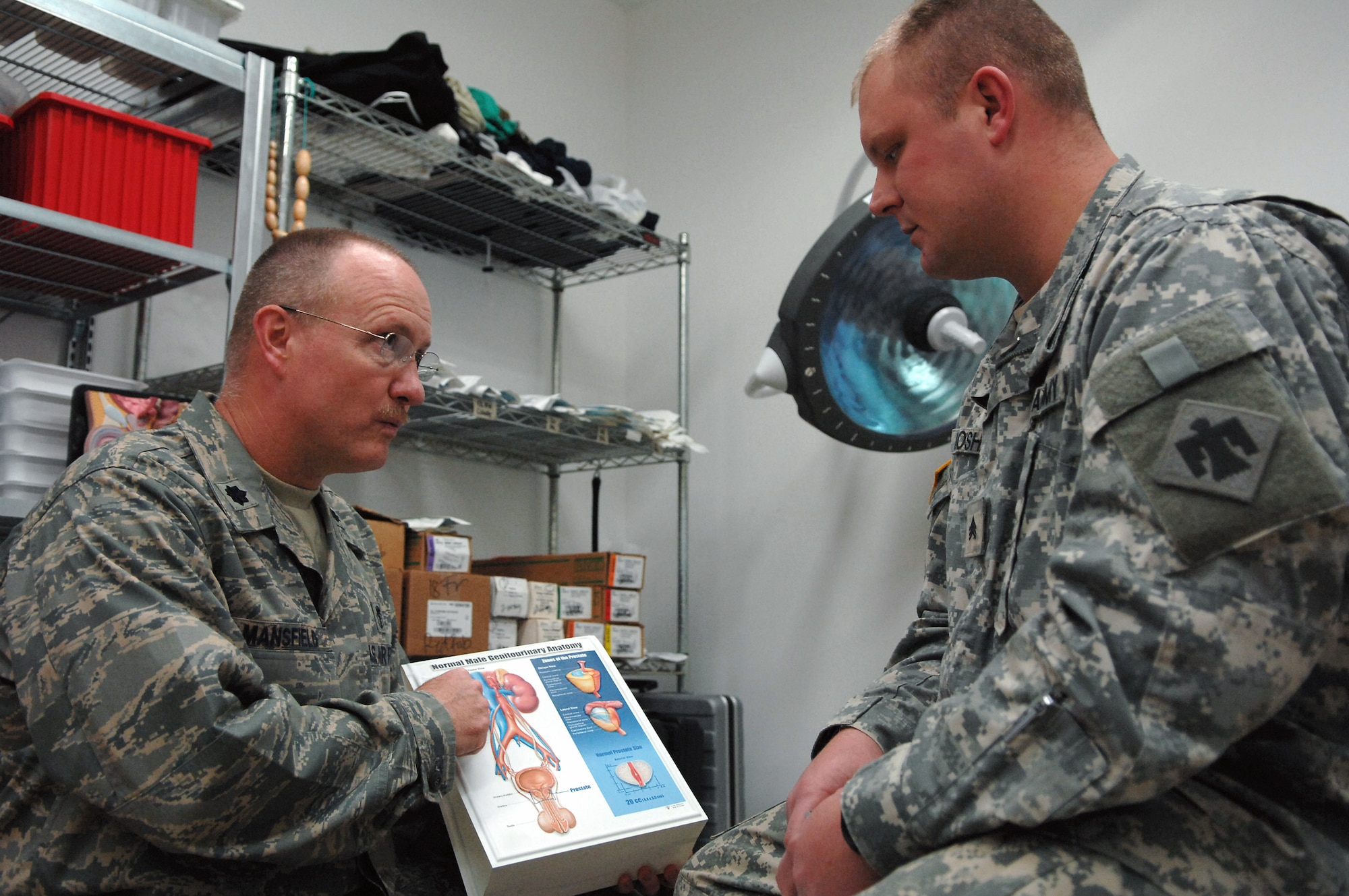 Col. (Dr.) John Mansfield discusses kidney stone disease with Army Sgt. Robert Mosher, 345th Support Battalion. Sergeant Mosher had laser surgery treatment at the Air Force Theater Hospital at Balad Air Base, Iraq, to remove a kidney stone. He was away from his unit at Camp Cropper, Iraq, for seven days while he was receiving treatment and recovering. Doctor Mansfield is a 332nd Expeditionary Medical Operations Squadron urologist.  (U.S. Air Force photo/Senior Airman Julianne Showalter)