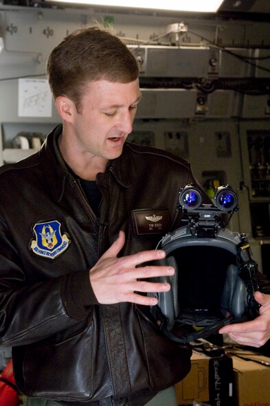 Maj. Thomas Jensen, a pilot with the 97th Airlift Squadron, displays a set of night vision goggles that make flight operations possible even in complete darkness. Operation Deep Freeze is comprised of a Total Force team featuring personnel from the 62nd Airlift Wing and the 446th Airlift Wing. (U.S. Air Force photo/Abner Guzman)
