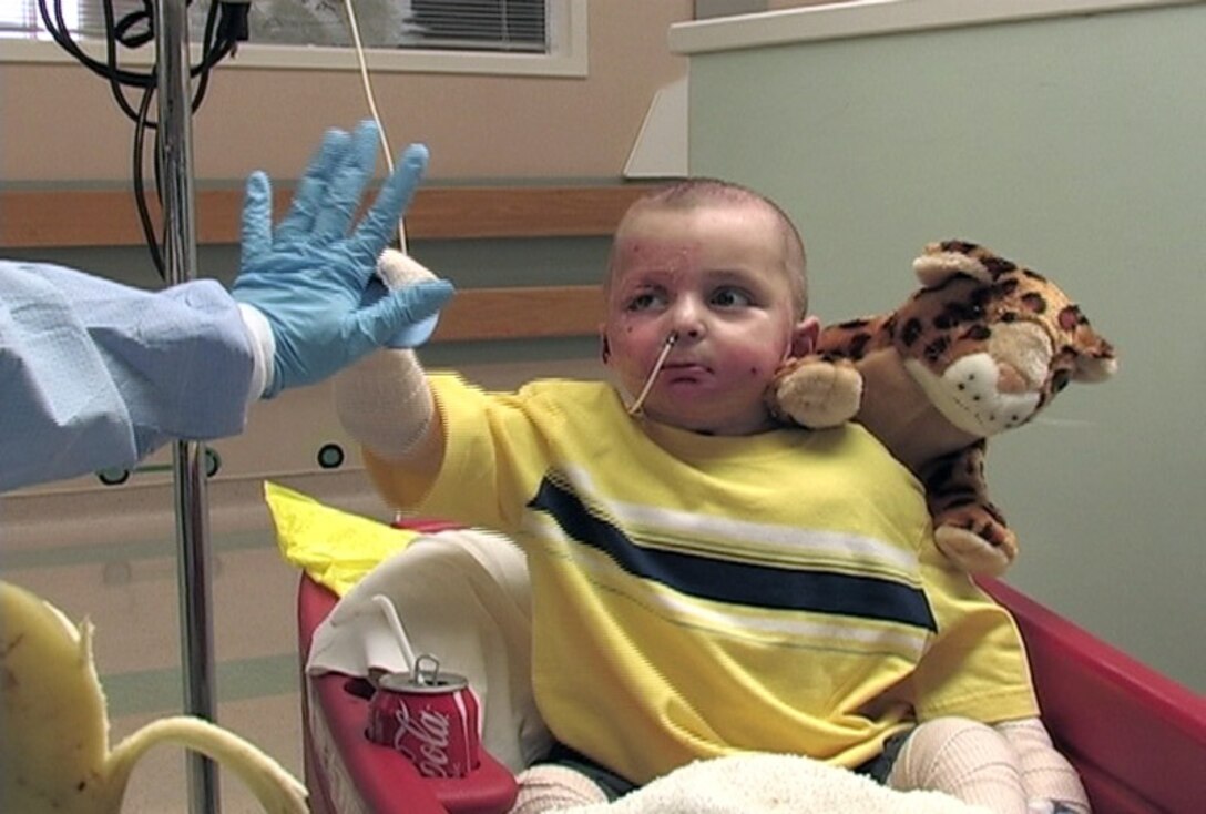 Al Amreeki gives a high five to his interpreter, Nadia Shaya, April 10 at Shriners Hospital in Cincinnati. The 3-year-old left Balad Air Base, Iraq, with more than 45 percent of his body burned from a stove fire at his home and Airmen and medics have helped nurse him back to health. (U.S. Air Force photo/Ken LaRock) 