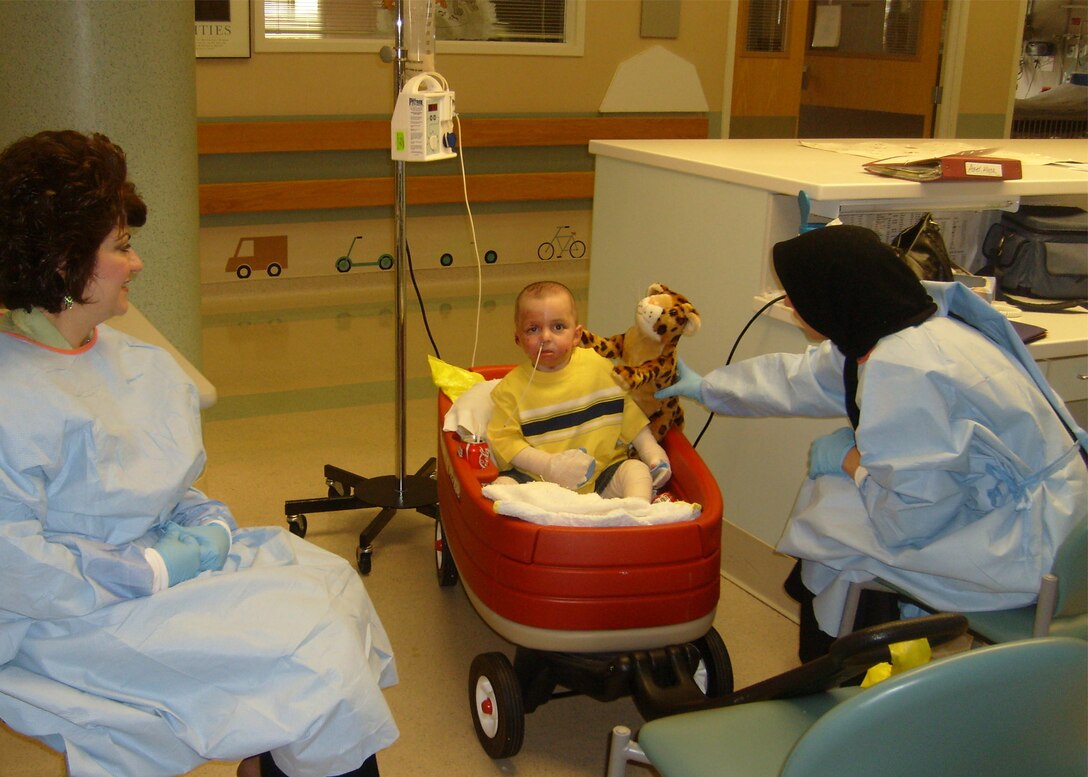 Al Amreeki receives a stuffed toy from his mother, Amil, April 10 at Shriners Hospital in Cincinnati. The 3-year-old left Balad Air Base, Iraq, with more than 45 percent of his body burned from a stove fire at his home and Airmen and medics have helped nurse him back to health. (U.S. Air Force photo/Jeannie Masters) 