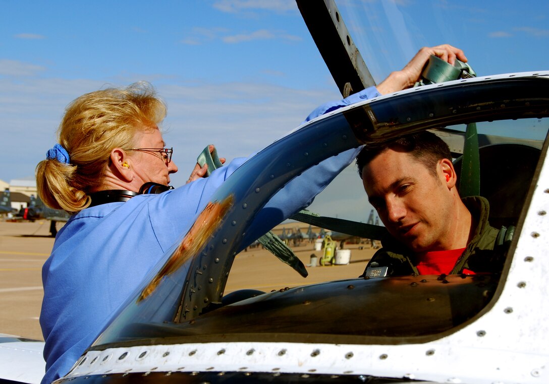 Doris Castle, left, helps 89th Flying Training Squadron instructor pilot Capt. Dick Stringer with his shoulder harnesses before a flight April 11. Ms. Castle, a 25-year veteran crew chief with Lear Siegler Services, Inc., and other crew chiefs are the last in Air Education and Training Command to launch and retrieve the T-37 Tweet. The 80th Flying Training Wing is the last in the Air Force to make the conversion to the T-6A Texan II.