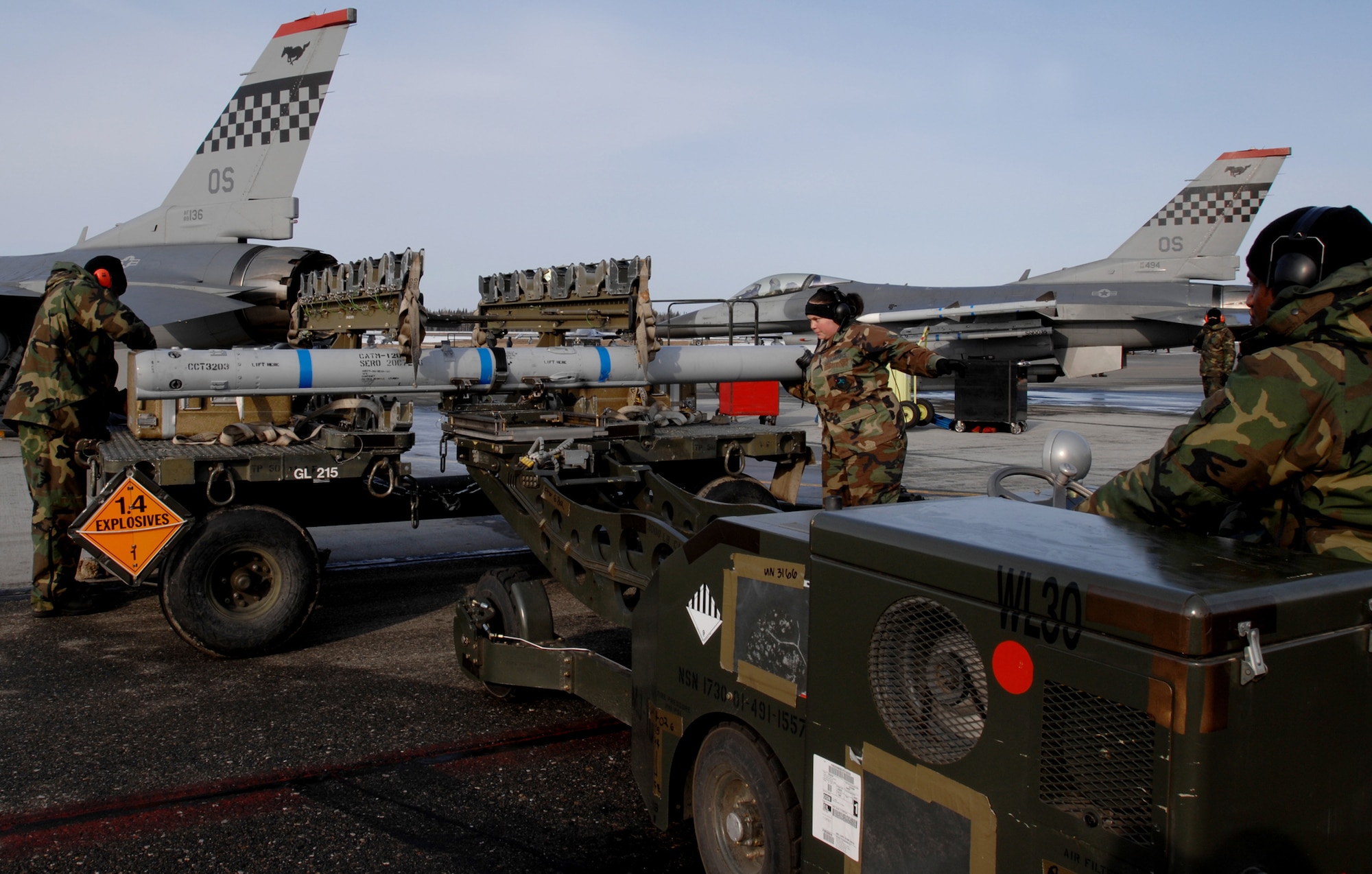 Staff Sgt. Toni Sanchez (center) directs Staff Sgt. Marty Shorter (right) to slowly back up the bomb loader vehicle to transport an AIM-120 missile to an F-16 Fighting Falcon as Staff Sgt. Kenny Williams (left) searches for the correct tools to install the AIM-120 onto the F-16 April 9, 2008, during pre-flight preparations for RED FLAG-Alaska 08-02 exercise are here at Eielson Air Force Base, Alaska. The sergeants are from the 36th Fighter Squadron, Osan Air Base Korea.  RED FLAG-Alaska is a series of Pacific Air Forces field training exercises for U.S forces and allies of the U.S that provide joint offensive counter-air, interdiction, close air support, and large forces employment training in a simulated combat environment.

(U.S Air Force Photo by Tech Sgt. Eric T. Sheler)
