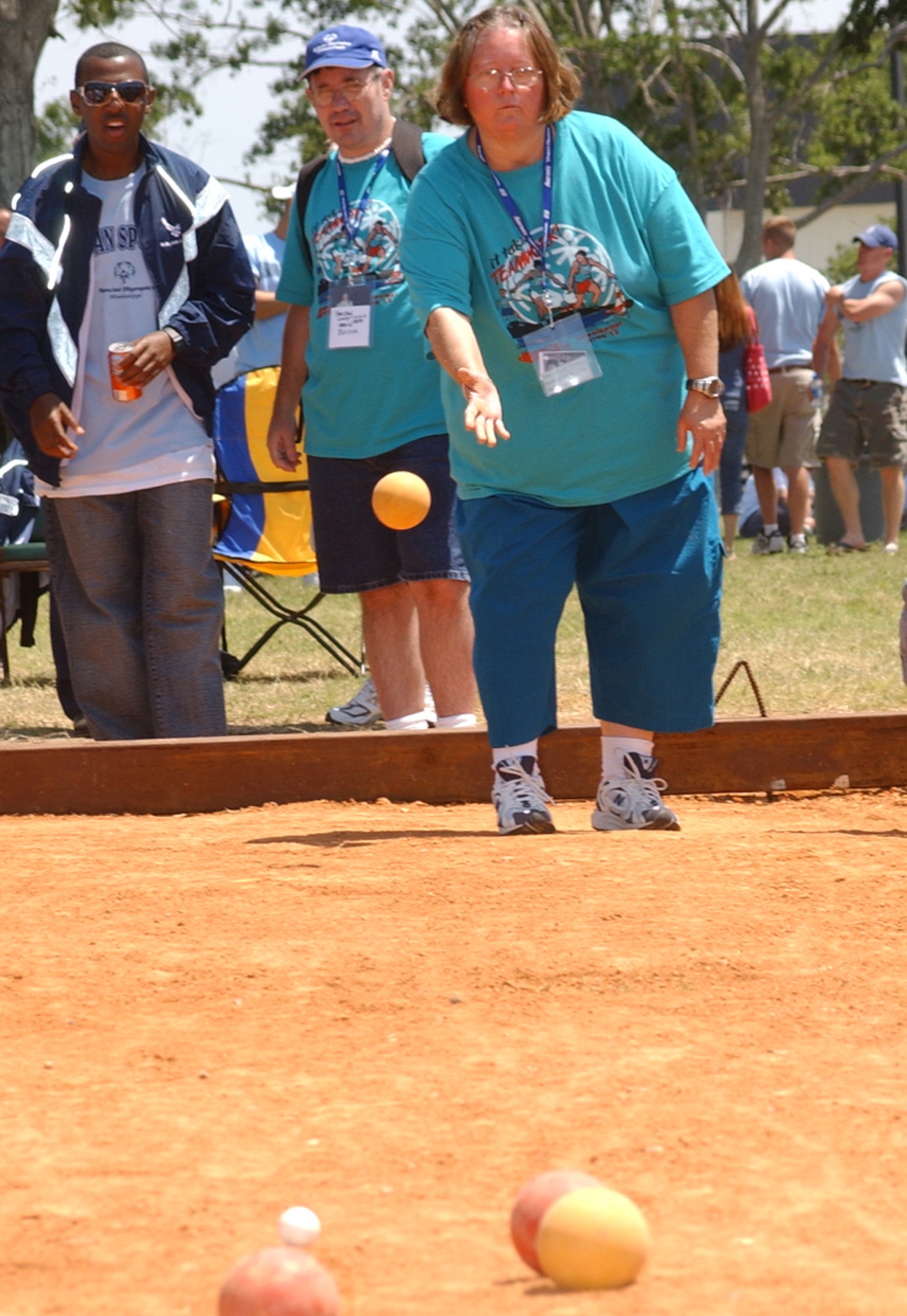 Donna Tillman, Area 12, throws a bocce ball Saturday at the Triangle Track as an Airman sponsor looks on.  Each athlete was assigned two Airman sponsors to bunk with and escort them throughout the weekend.  (U.S. Air Force photo by Kemberly Groue)
