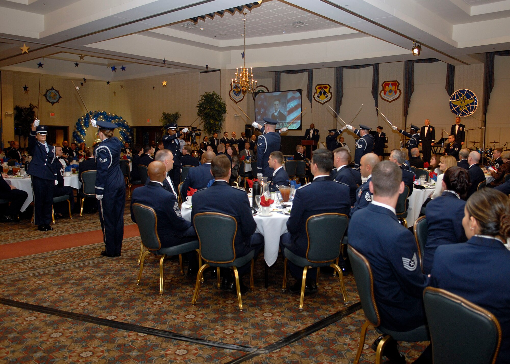 SCOTT AIR FORCE BASE, Ill. – Scott Air Force Base Honor Guard members hold their swords to form a cordon for the 12 Outstanding Airmen nominees to walk through and be recognized on stage with Gen. Arthur J. Lichte, Air Mobility Command commander, and Chief Master Sgt. Joseph Barron, AMC command chief. (U.S. Air Force photo/Airman 1st Class Megan Gilliland)