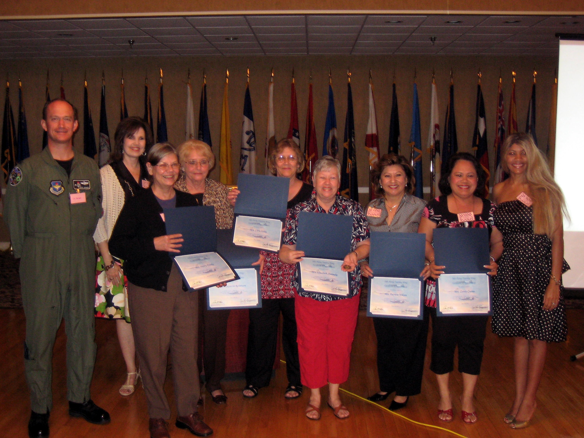 These ladies were honored for their volunteer service to the Base Thrift Shop, totaling 40 years of combined volunteer service.  A portion of the profits from the Thrift Shop fund the Annual Scholarship Awards given out by the OSC.  Pictured are: Col. Dave Gerber, Susan Dunn, Nancy Franks, Jaynette Robertson, Chris Haley, Elizabeth Shoemake, Patricia Wilson, Zenny Cuomo, and OSC president Sarah Dixon. Not pictured: Sue Weiger. (U.S. Air Force photo by AIrman Josh Harbin)