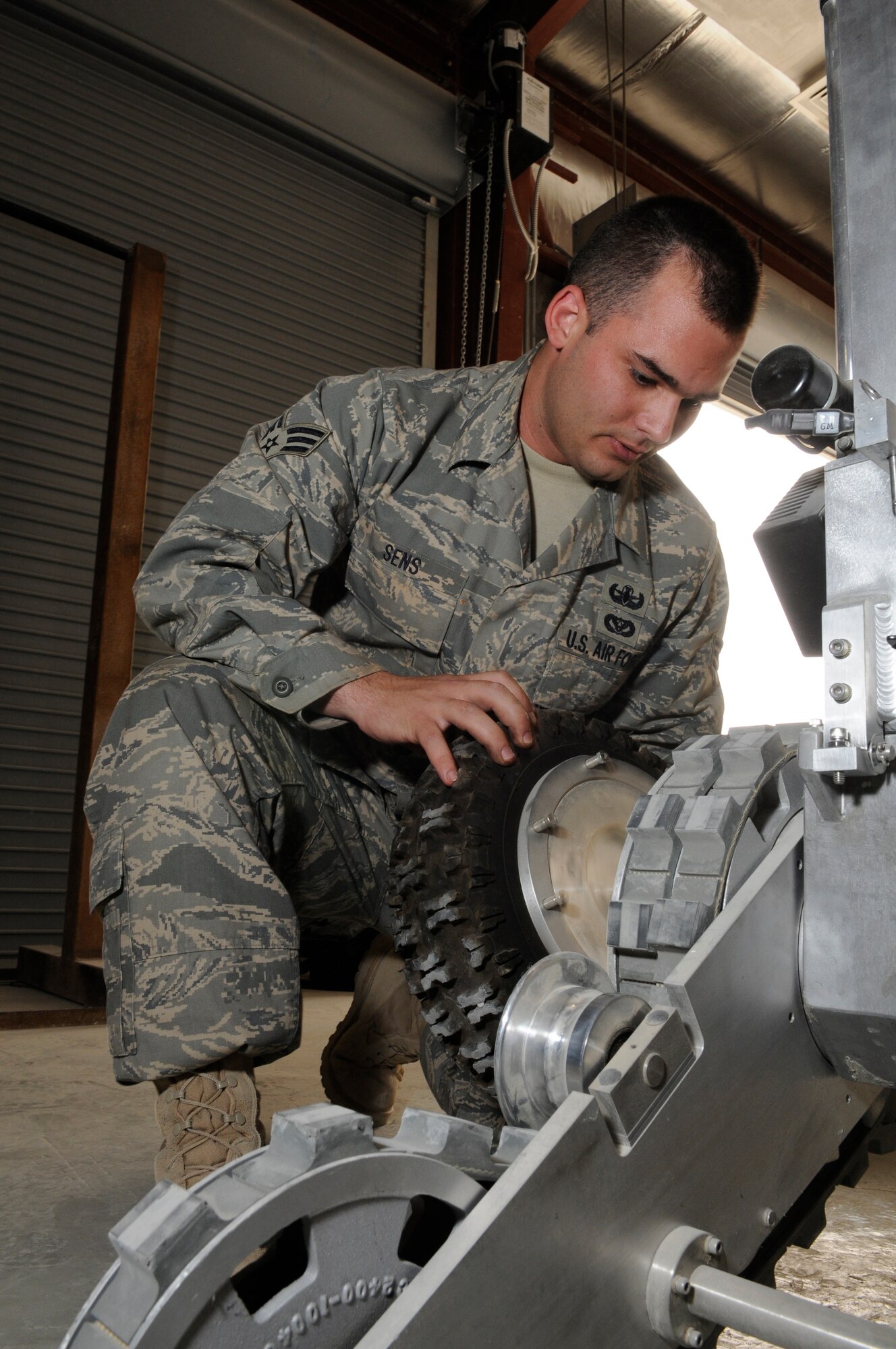 Senior Airman Paul Sens removes an optional rubber tire from a  robot here. He performs preventive maintenance to ensure the robot is ready at a moment’s notice. He is originally from New Orleans, La. deployed from Eglin Air Force Base, Fla.   (U.S. Air Force photo/Tech. Sgt. Johnny L. Saldivar)