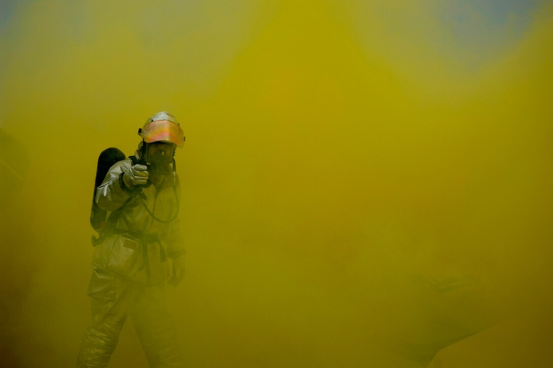 An Airman from the Charleston Air Force Base, S.C., fire department walks through smoke that simulates an aircraft crash on the Charleston AFB flightline as part of a routine training exercise.  (U.S. Air Force photo/Senior Airman Nicholas Pilch)