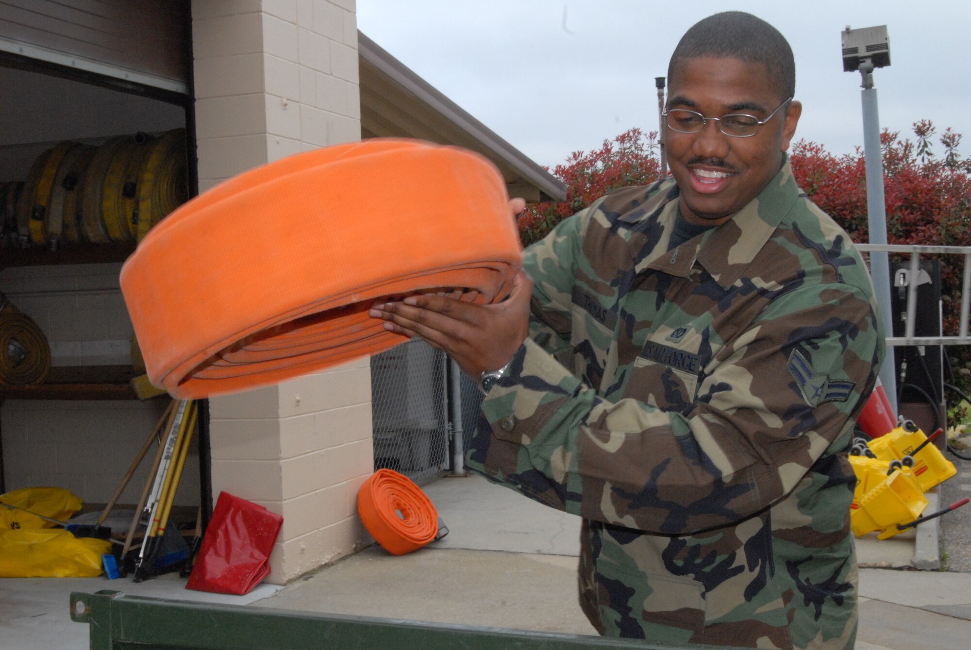 Airman Von Carl Thomas, 43rd Civil Engineer Squadron, loads a three-inch hose into the utility vehicle near the fire department's garage April 6. (U.S. Air Force Photo by Airman 1st Class Mindy Bloem)