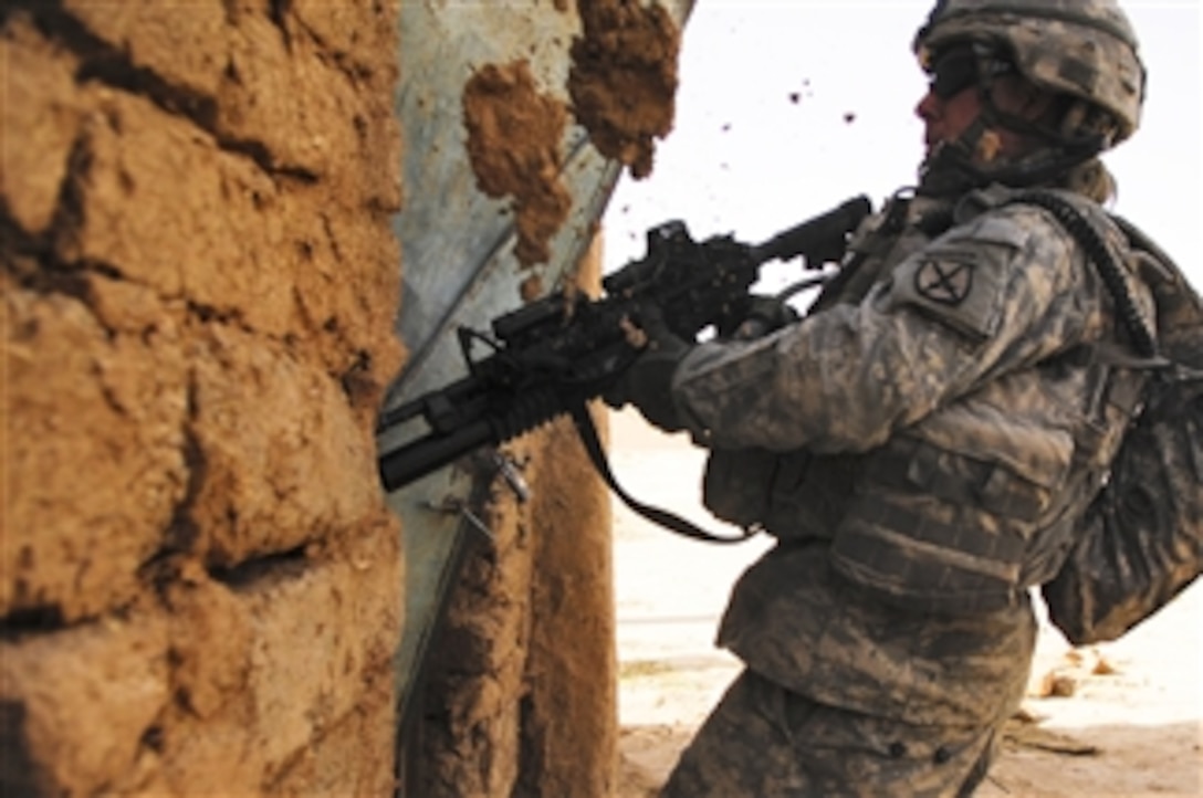 U.S. Army Pfc. Adam Bobler, of 3rd Platoon, Delta Company from the 2nd Battalion, 22nd Infantry Regiment, 10th Mountain Division, kicks down a door during a three-day air assault mission to search for weapons caches and high value insurgents in Upper Dugmut, Iraq, on April 4, 2008.  