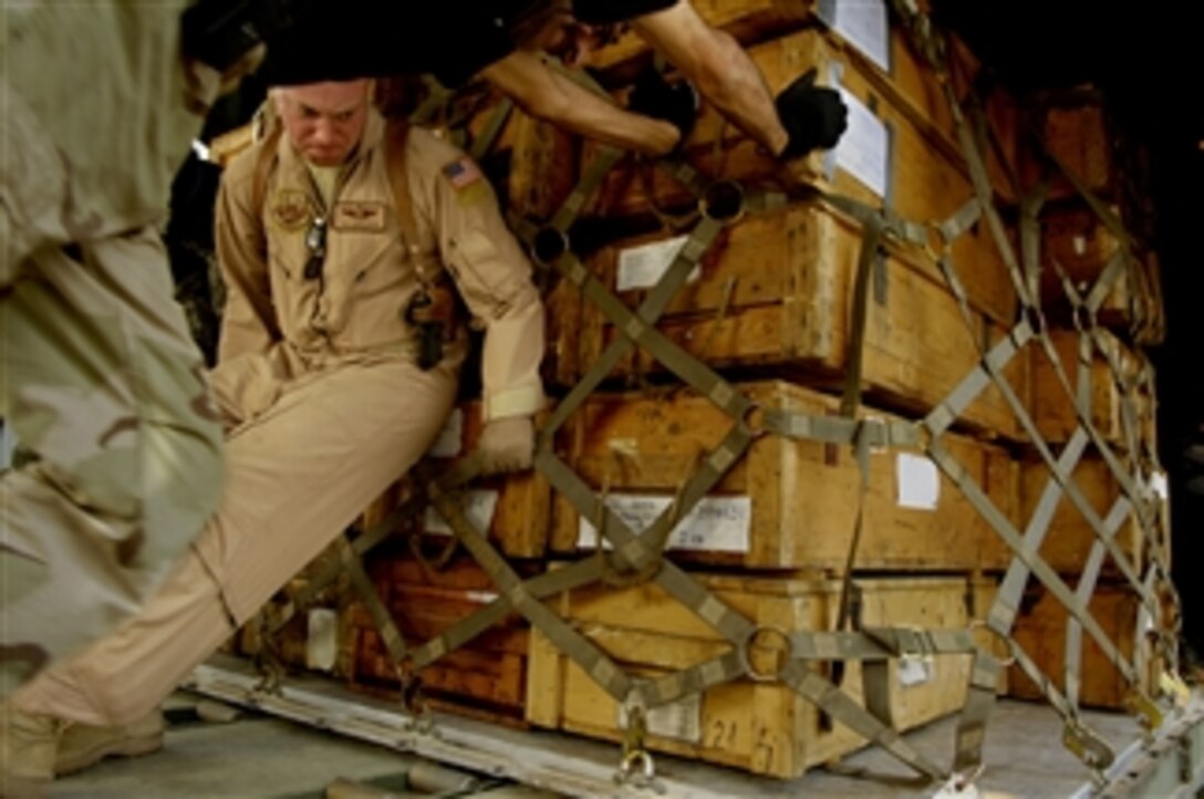 U.S. Air Force Tech. Sgt. Mark Blinn, a loadmaster advisor with Coalition Air Force Training Team, and Iraq air force airmen push a pallet of ammunition into an Iraqi air force C-130 Hercules aircraft at New Al Muthana Air Base, Iraq, on April 6, 2008.  