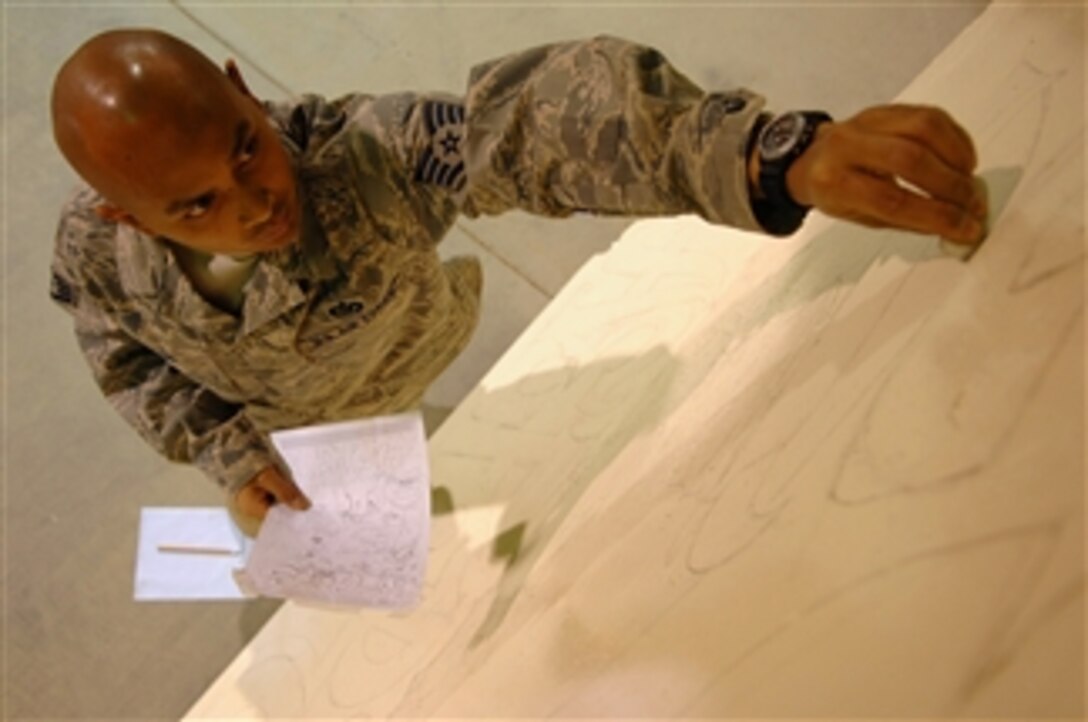 U.S. Air Force Staff Sgt. Paul On, an electrician with 332nd Expeditionary Civil Engineer Squadron, draws an image of a bull on a barrier wall at Balad Air Base, Iraq, on April 8, 2008.  On is using the bull, a symbol for U.S. Air Force civil engineers, in a comic strip he's drawing on the barrier wall to keep morale high in his unit.  
