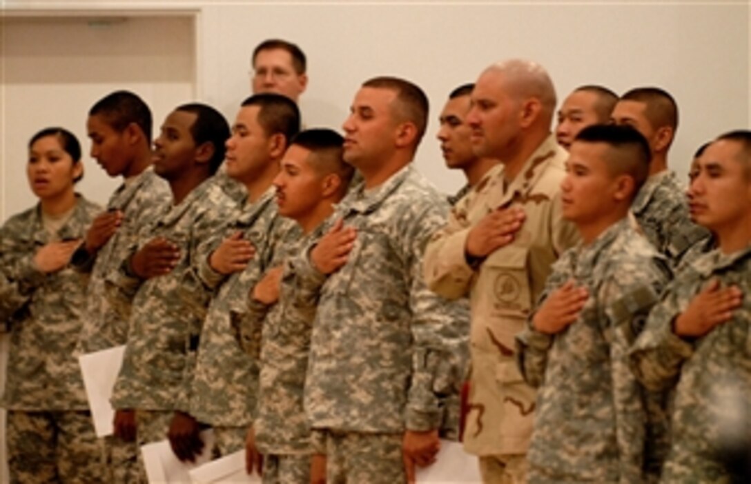 Sixty-two service members from 25 different countries place their right hand above their hearts as they recite the Pledge of Allegiance signifying their commitment to the United States during a Naturalization Ceremony, April 5, 2008. 