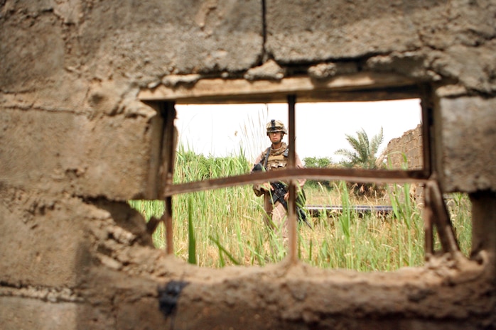 Lance Cpl. Michael S. Villapando, a team leader with Company F, 2nd Battalion, 24th Marine Regiment, Regimental Combat Team 1, patrols through a field during after checking out a weapons cache located by the Iraqi Police. The Marines have received tips from the Iraqi people and the Iraqi Security Forces on a regular basis on the locations of weapons caches and have 'struck it rich' with several weapons caches found recently thanks to the help of the Iraqi people.