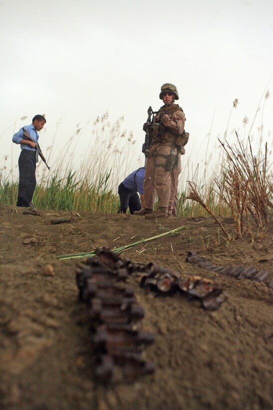 Sgt. Michael J. Anderson, a squad leader with Company F, 2nd Battalion, 24th Marine Regiment, stands over the sight of a possible enemy weapons cache April 11. The sight was located by the Iraqi Police, who regularly assist the Marines in locating weapons caches. This has become a major success in the disabling of the enemy weapons stronghold.