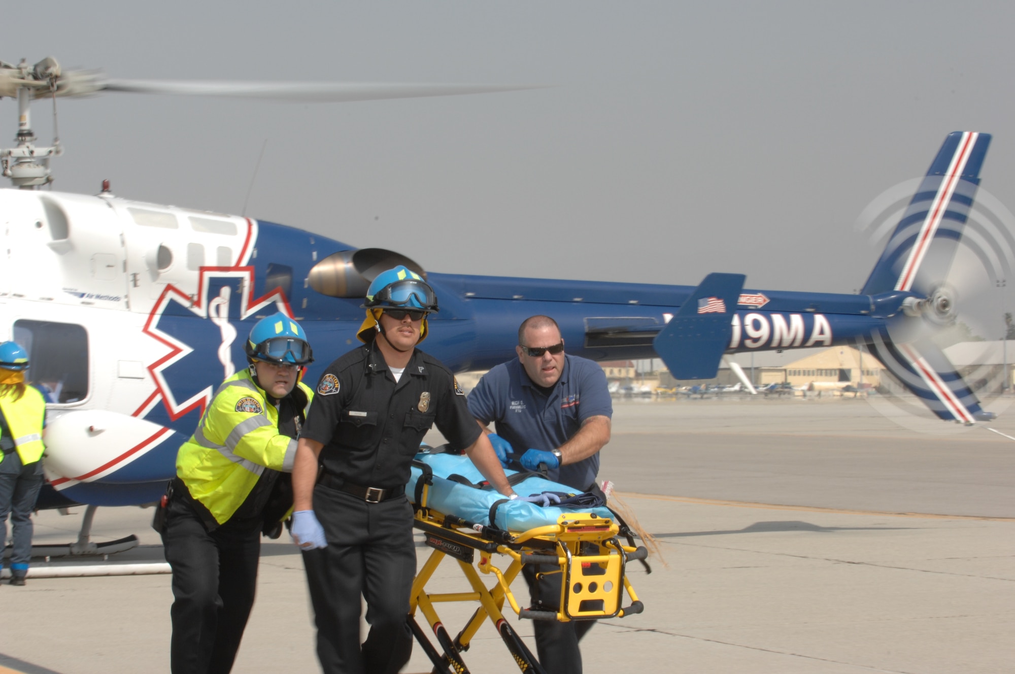 An emergency medical crew from Mercy Air runs to the accident scene to airlift casualties to a local hospital. Some one hundred disaster responders and injured actors recently participated in a mass casualty exercise held on the flight line at the base. The exercise involved several community partners, such as Riverside EMS, AMR and Mission ambulance. (U.S. Air Force photo by 4th CTCS)