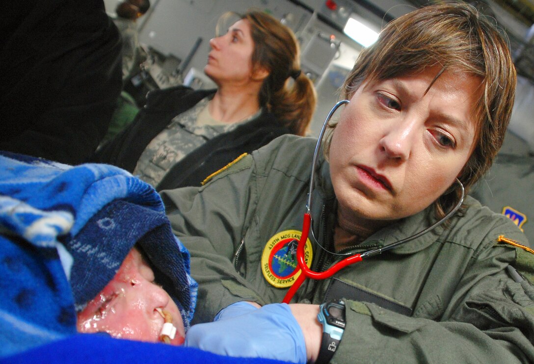 Navy Lt. Cmdr. (Dr) Michelle Perello checks vital signs on a young Iraqi boy on board
a March ARB C-17 Globemaster III. The boy is on his way from Balad Air Base, Iraq, to
a children’s hospital in Cincinnati. The flight stopped in Ramstein AB, Germany, where Dr. Perello handled the boy’s care. (U.S. Air Force photo)