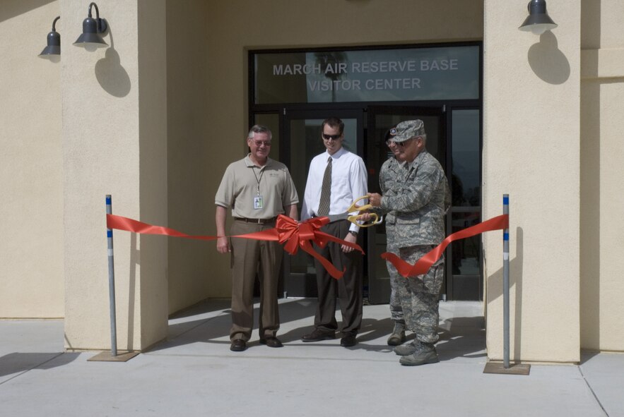 Brig. Gen. James Melin, 452nd Air Mobility Wing commander, cuts the ribbon to officially open the new visitor’s center. Jim Rossi, SSI project manager, left, Ryan Wood, acting base civil engineer, and Lt. Col. Cary Conners, 452nd Security Forces Squadron commander, join in the ceremony. The new roundabout requires drivers to pay attention to directional signs which lead them either into the base or to the parking lot of the visitor’s center. There also is a commercial truck inspection turnout and an exit base lane.  Almost 100,000 vehicles a month will pass through the roundabout and visitor’s center which General Melin noted was the “Gateway to the Base.” (U.S. Air Force photo by MSgt. Stan Thompson, 163 RW/PA)