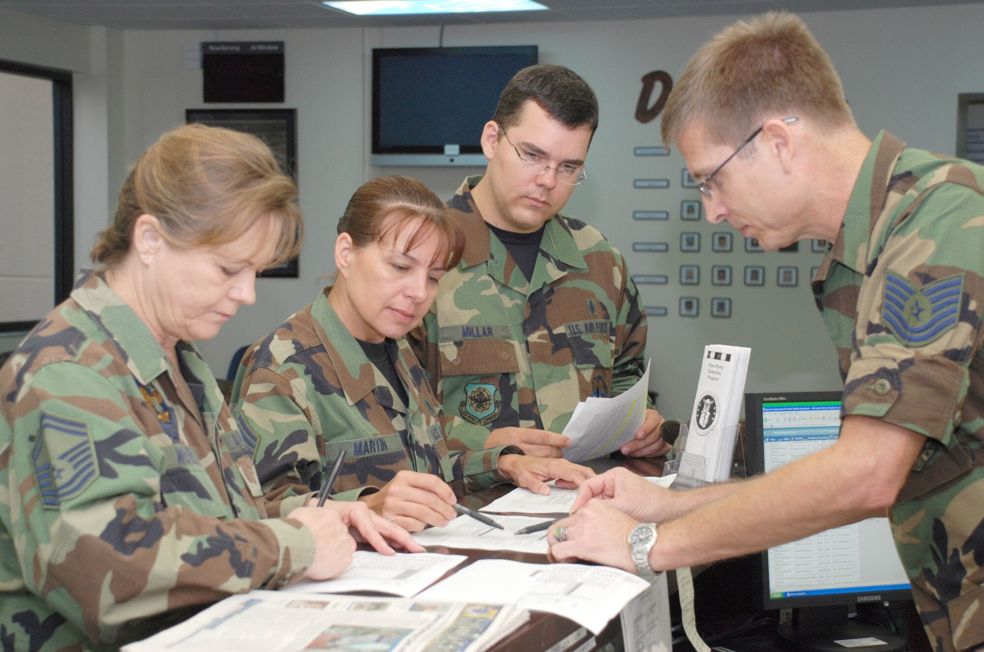 PATRICK AIR FORCE BASE, Fla. - Air Force Reservists (From left) Senior Master Sgt. Donna Wenzel, Chief Master Sgt. Dorlen Martin, Tech. Sgt. Christopher Millar and Tech. Sgt. Frank Smith, 920th Aeromedical Staging Squadron, review patient check-in lists at the base clinic. A new 920th Rescue Wing clinic schedule offers physicals every-other drill weekend. Profiles, warfit, immunizations and follow-ups are offered every Sunday of each drill weekend. Being healthy is a vital part of being war-ready.  Air Force Reservists serve on the frontlines and on the leading edge of technology in air, space and cyberspace, providing the Air Force a warfighting capability that is the best in the world. (U.S. Air Force Photo/Staff Sgt. Heather L. Kelly)