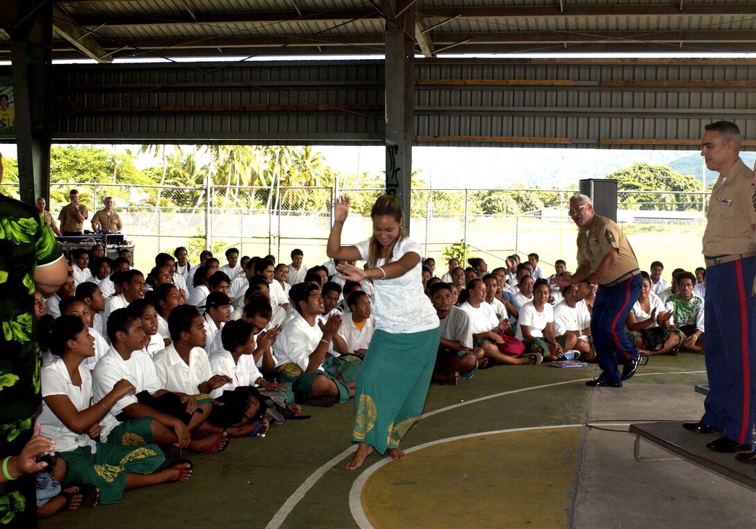 Leone High School Senior Olita Hollister and Master Gunnery Sgt. Joseph Elisara perform a traditional Samoan dance after the U.S. Marine Corps Forces, Pacific Band's performance at the school as part of the 108th anniversary of the American Flag Raising over American Samoa, April 14th.