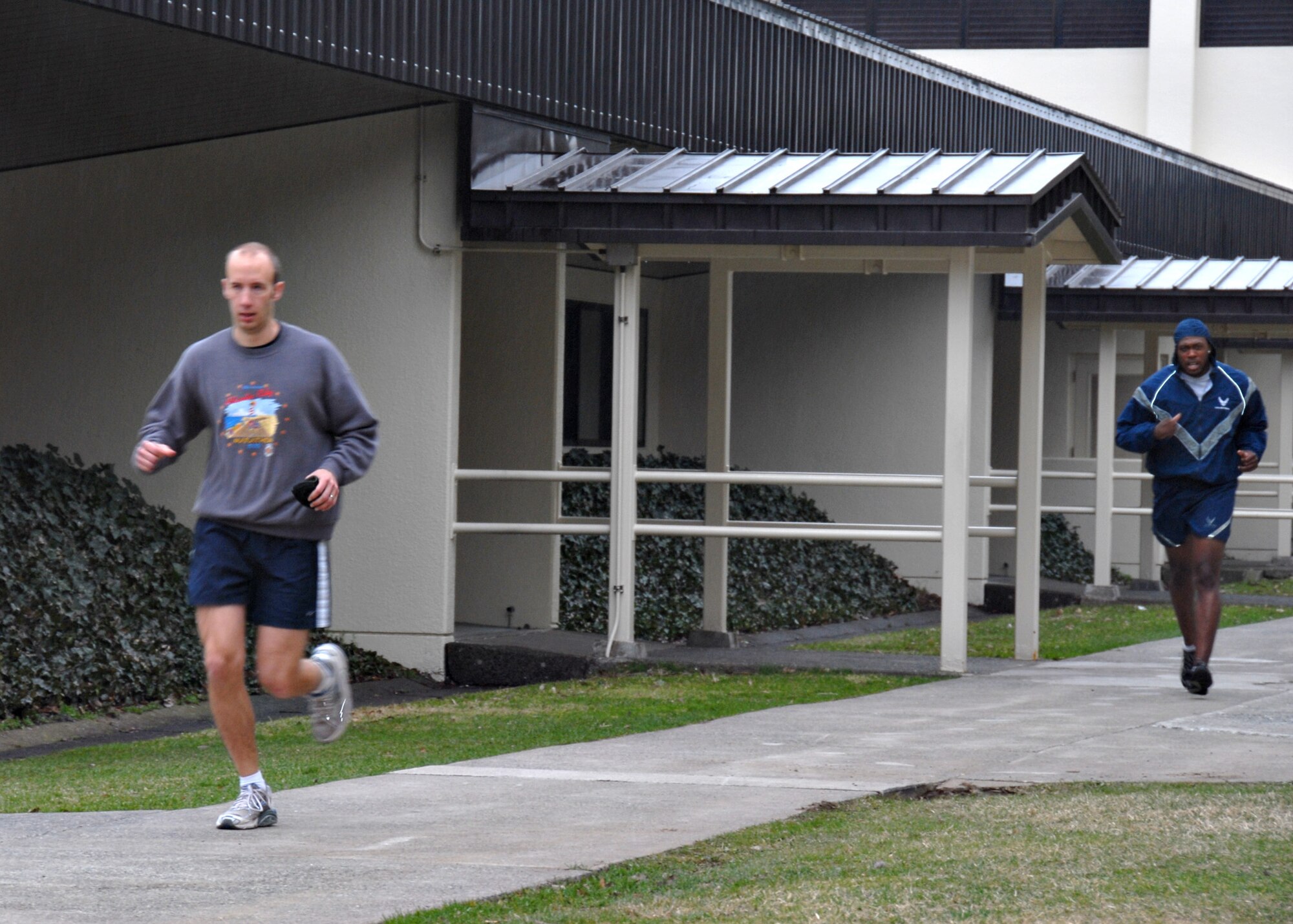 MISAWA AIR BASE, Japan -- Lindsay Buckalew (left), Misawa Air Base exercise physiologist, runs with a member of the 35th Civil Engineer Squadron during a morning PT session here April 14, 2008. As a part of his job, Mr. Buckalew said it will not be uncommon to see him joining units for PT. "It's my job to be in shape myself. If I am going to talk the talk then I need to walk the walk," he said. 