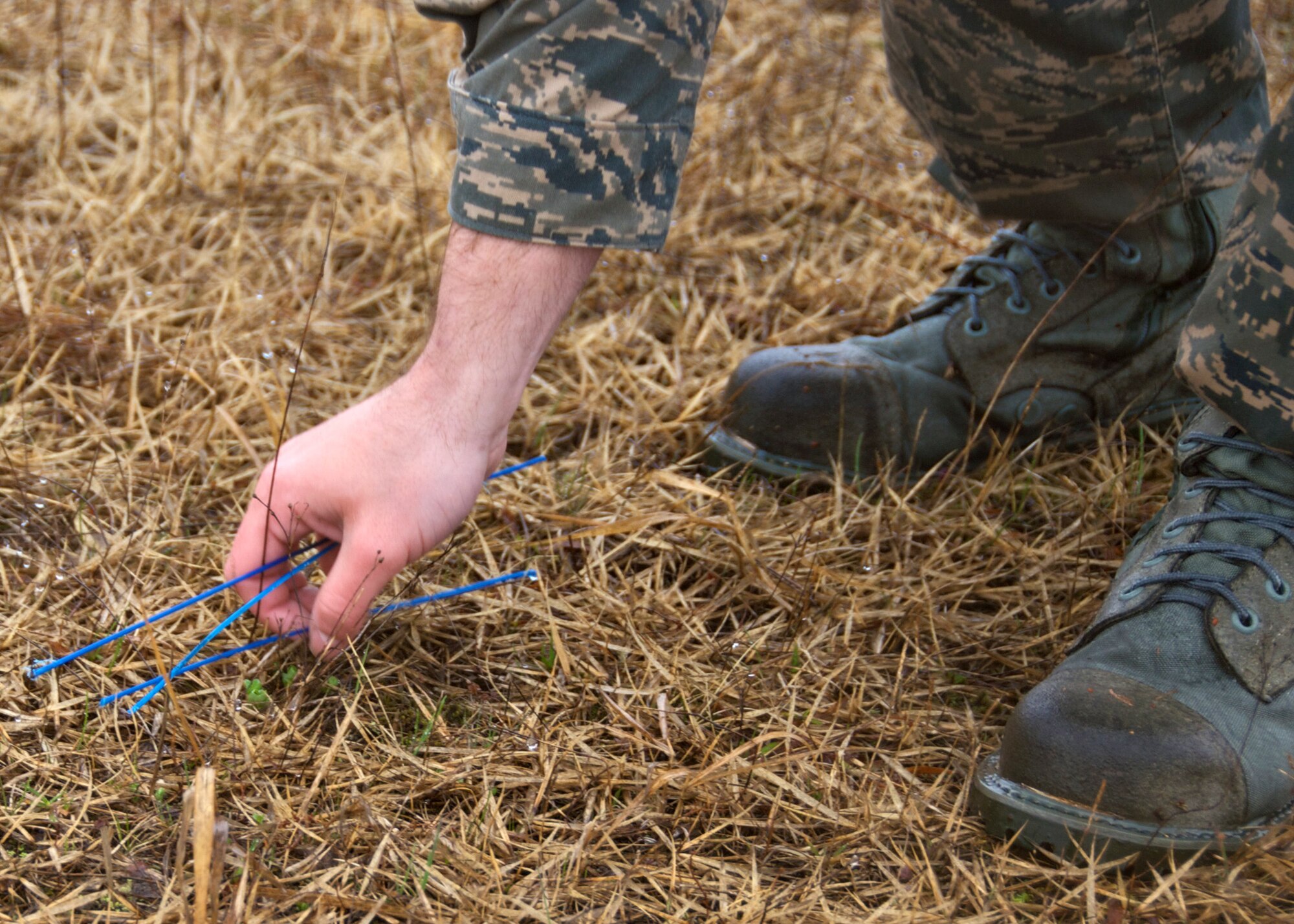MISAWA AIR BASE, Japan -- An Airman picks up debris on the airfield during the base FOD walk here April 11, 2008. The annual base FOD walk is typically held after the snow melts and is intended to clear the airfield of debris such as these blue bristles left by snow plows. (U.S. Air Force photo by Senior Airman Chad Strohmeyer)