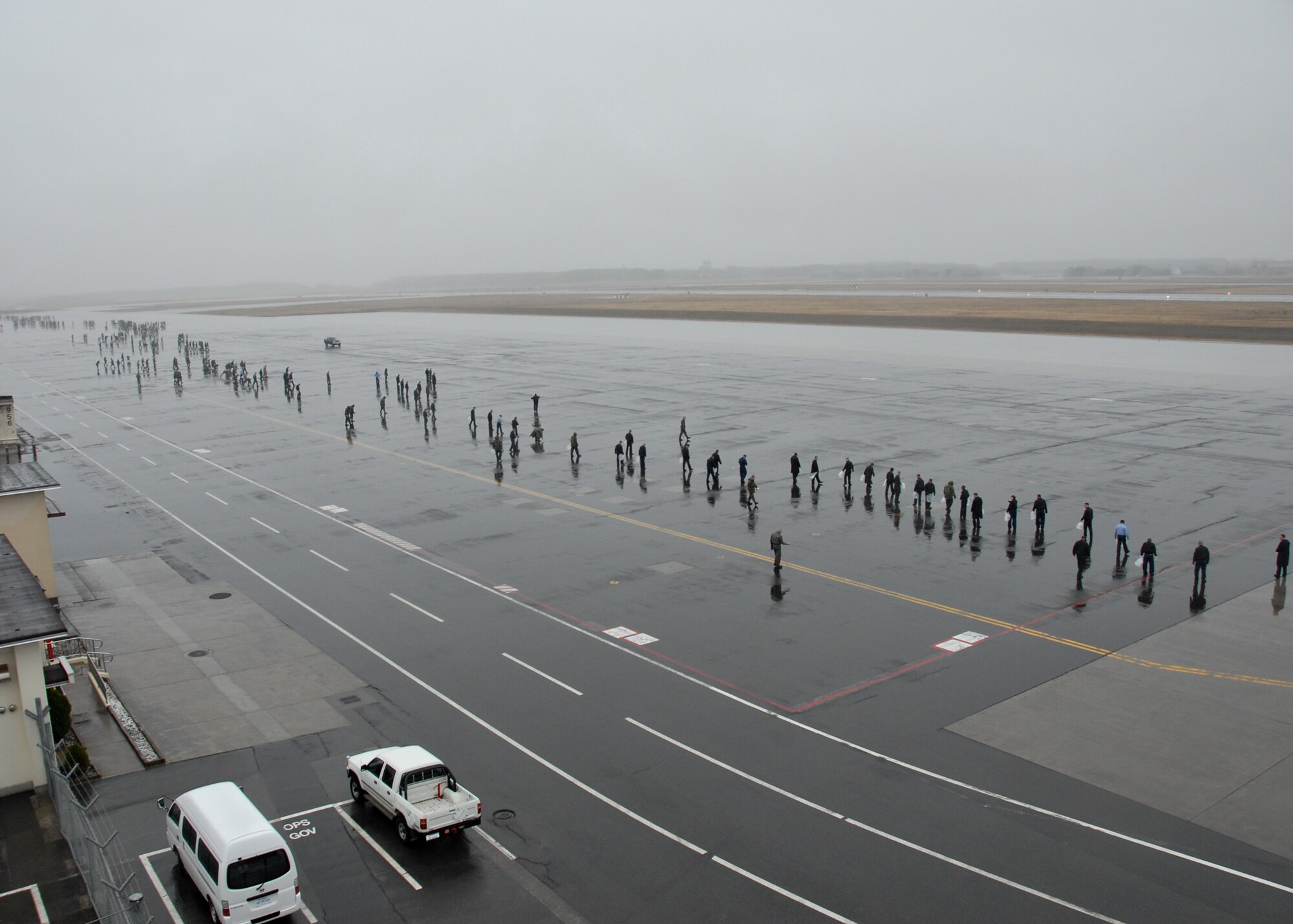 MISAWA AIR BASE, Japan -- Military personnel cover the flightline during a FOD walk here April 11, 2008. FOD, short for foreign object damage, refers to the debris that if left on an airfield could be sucked into a jet engine and cause damage. (U.S. Air Force photo by Senior Airman Laura R. McFarlane)