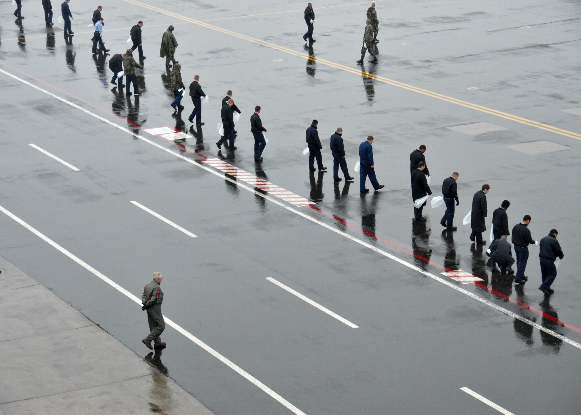 MISAWA AIR BASE, Japan -- Navy personnel personnel begin a FOD walk on the flightline here April 11, 2008. Military and civilian personnel from the entire base participate in this annual event designed to keep the flighline free from debris. (U.S. Air Force photo by Senior Airman Laura R. McFarlane)