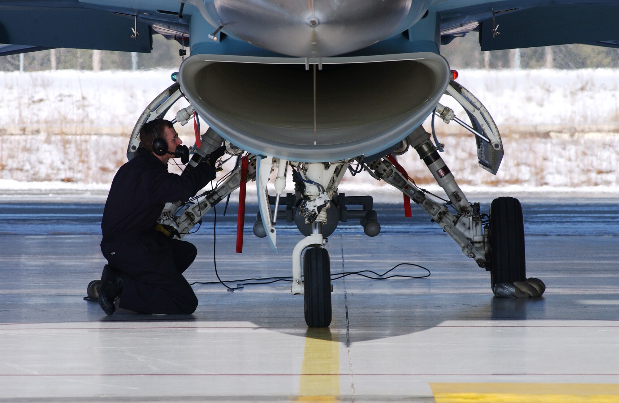 Airman 1st Class Clinton Gessler checks the landing gear on an F-16 Aggressor April 11, 2008, at Eielson Air Force Base, Alaska. During RED FLAG-Alaska 08-2 the 18th Aggressor Squadron act as the opposing force employing enemy tactics while engaging in aerial combat over the Pacific Alaskan Range Complex. Airman Gessler is a crew chief assign to the 354th Aircraft Maintenance Squadron. (U.S. Air Force Photo/Airman 1st Class Jonathan Snyder)